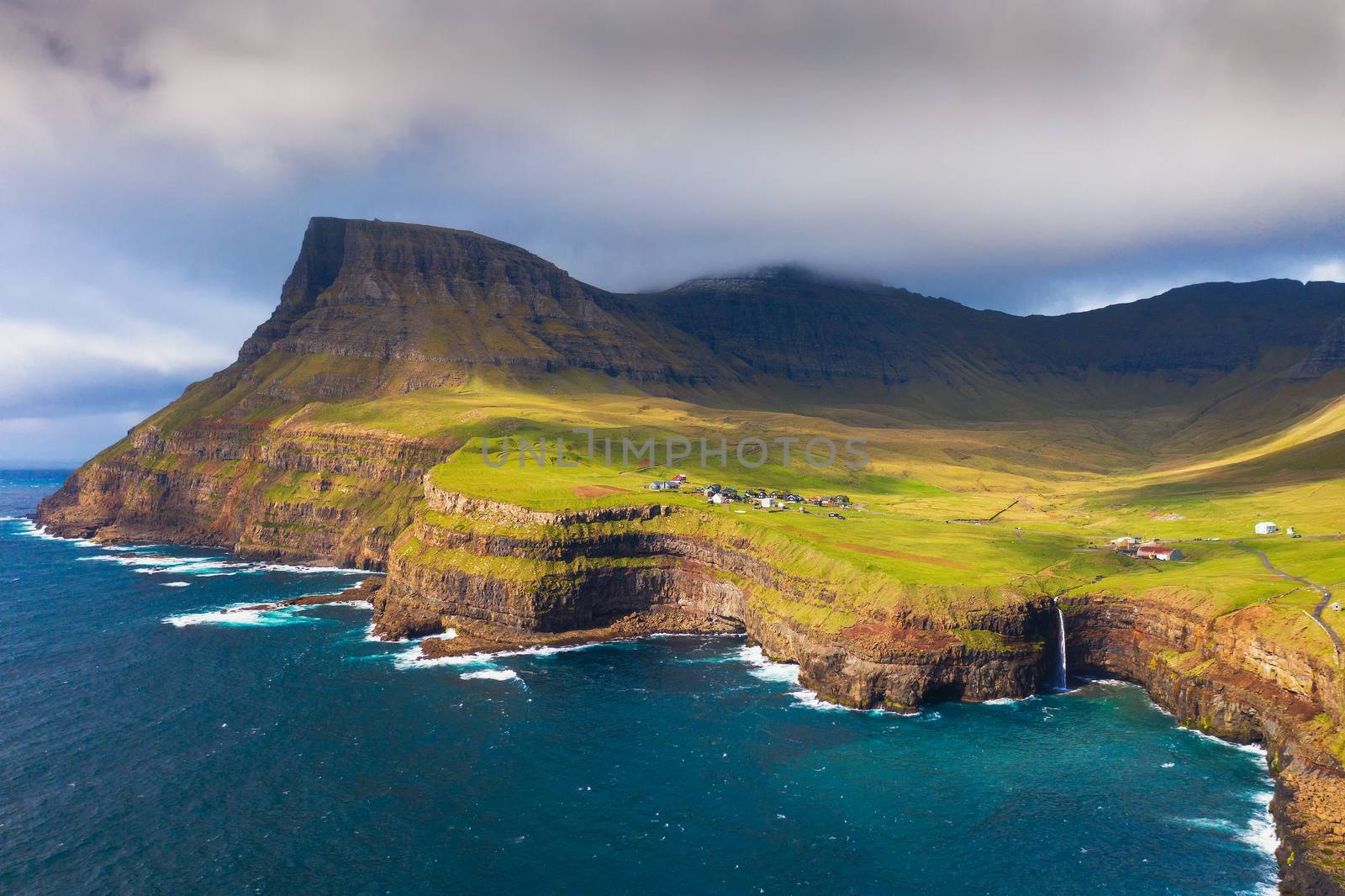 Aerial panorama of the Gasadalur village and its iconic waterfall in Faroe Islands, Denmark