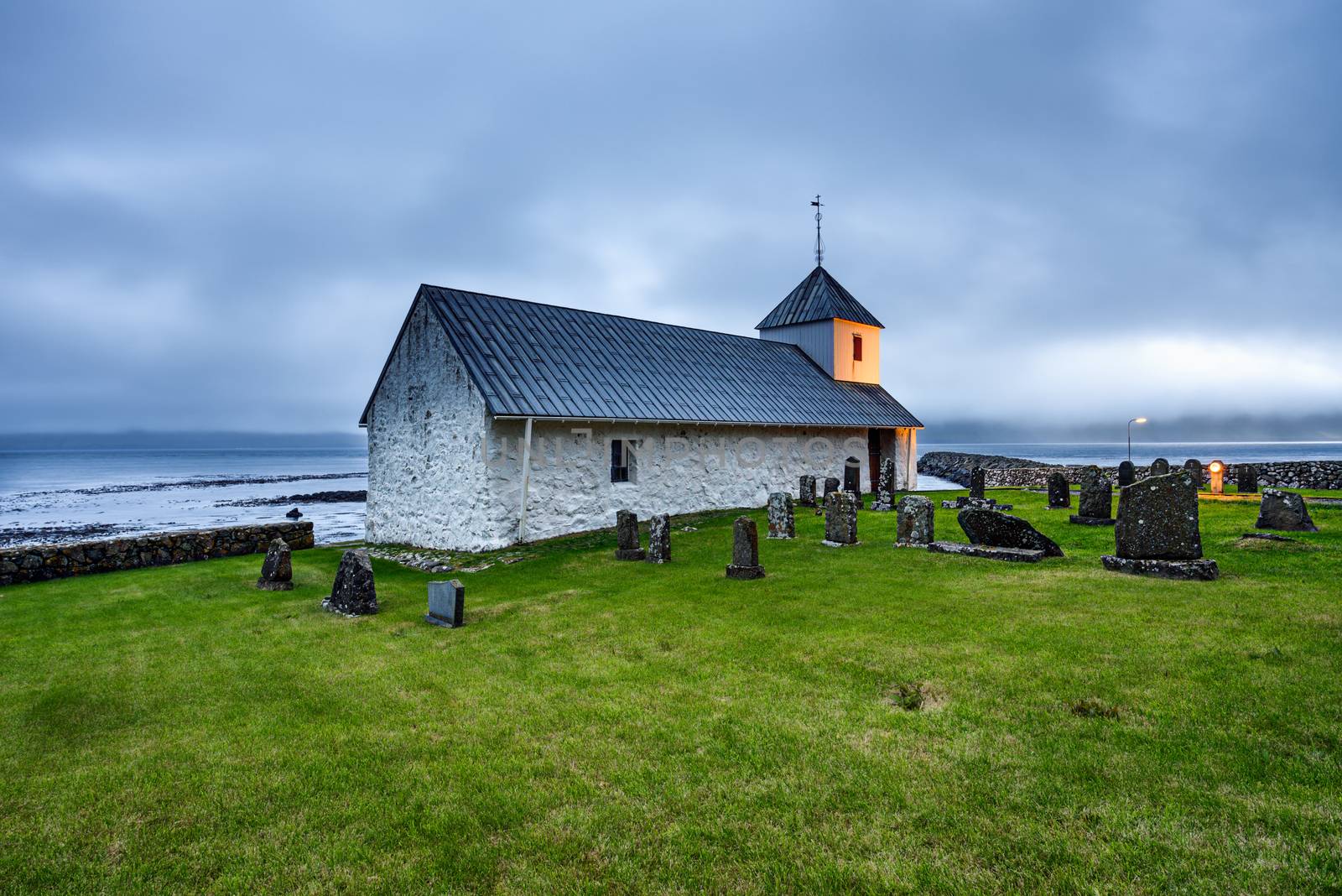 Small village church with cemetery in Kirkjubour, Faroe Islands by nickfox