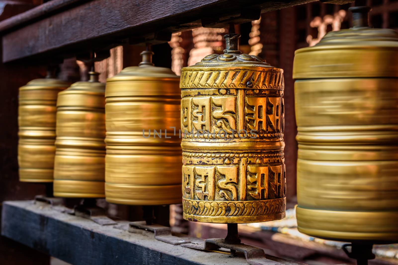 Golden tibetan prayer wheels in a Buddhist temple in Nepal by nickfox