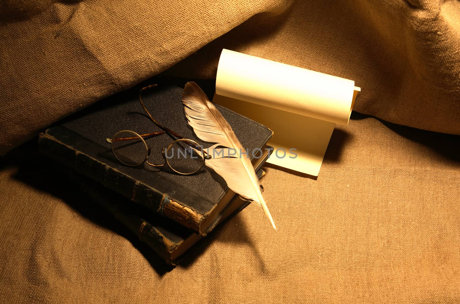 Vintage still life with old books and quill pen on canvas background