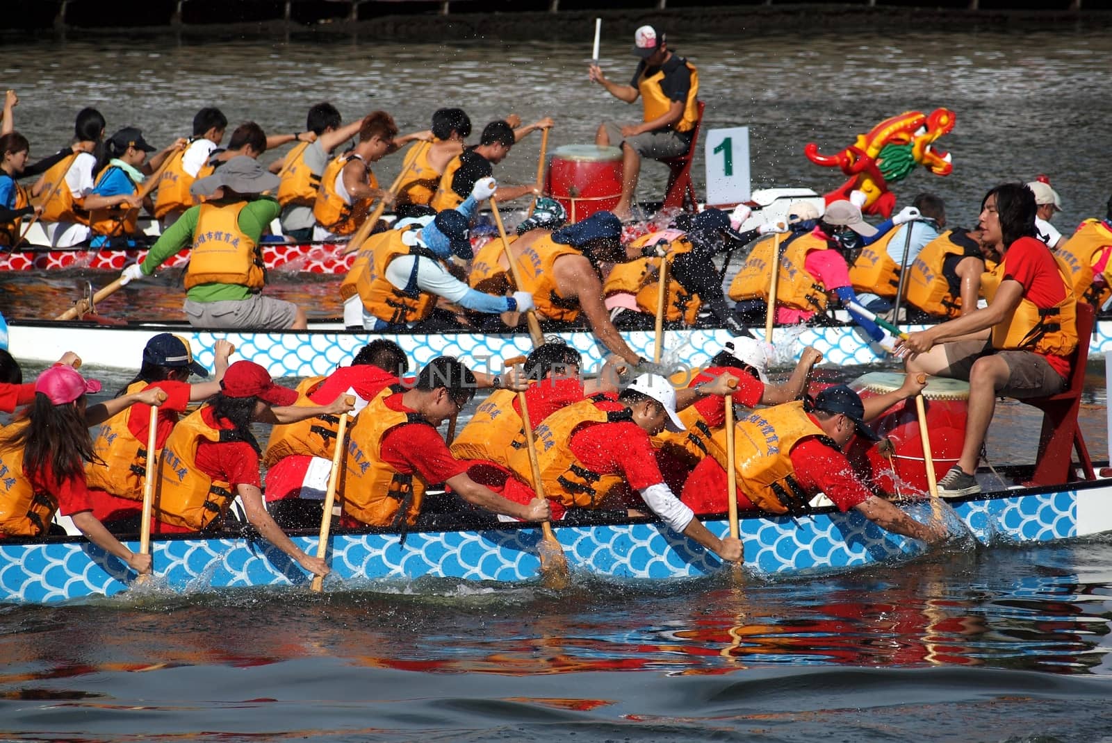 KAOHSIUNG, TAIWAN - JUNE 11: Three unidentified teams compete in the 2013 Dragon Boat Races on the Love River on June 11, 2013 in Kaohsiung