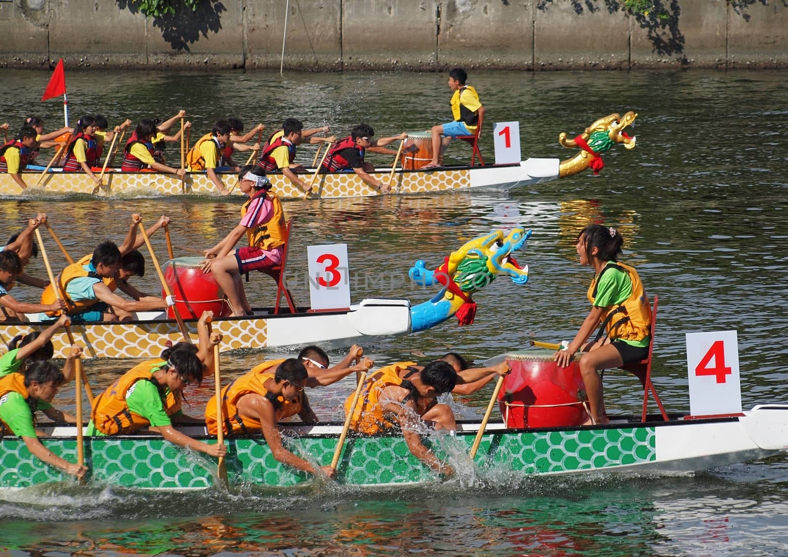 KAOHSIUNG, TAIWAN - JUNE 11: Three unidentified teams compete in the 2013 Dragon Boat Races on the Love River on June 11, 2013 in Kaohsiung