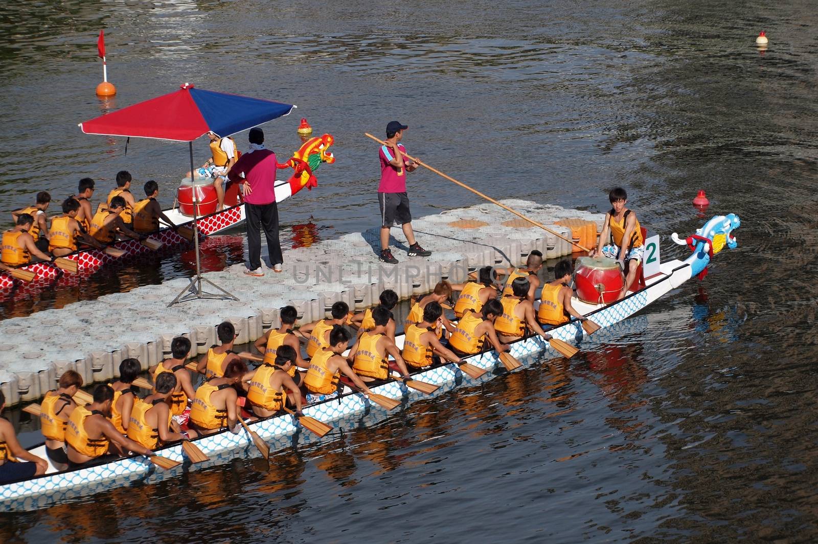 KAOHSIUNG, TAIWAN - JUNE 11: Two unidentified teams prepare to compete in the 2013 Dragon Boat Races on the Love River on June 11, 2013 in Kaohsiung