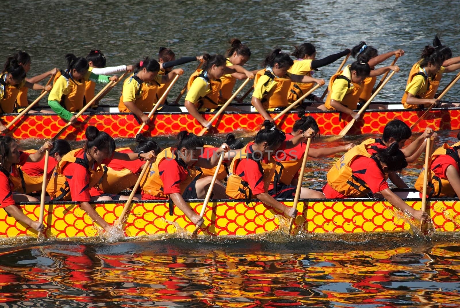 KAOHSIUNG, TAIWAN - JUNE 11: Two unidentified female teams compete in the 2013 Dragon Boat Races on the Love River on June 11, 2013 in Kaohsiung