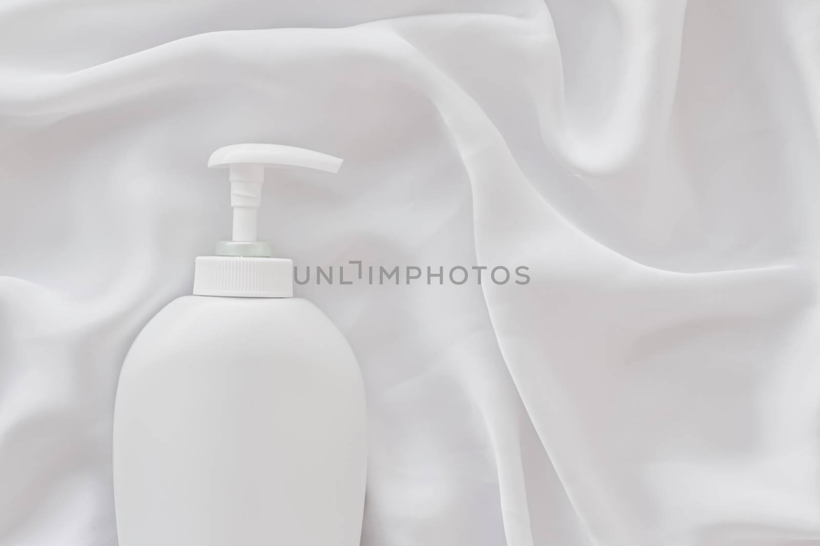 Blank label cosmetic container bottle as product mockup on white silk background, hygiene and healthcare