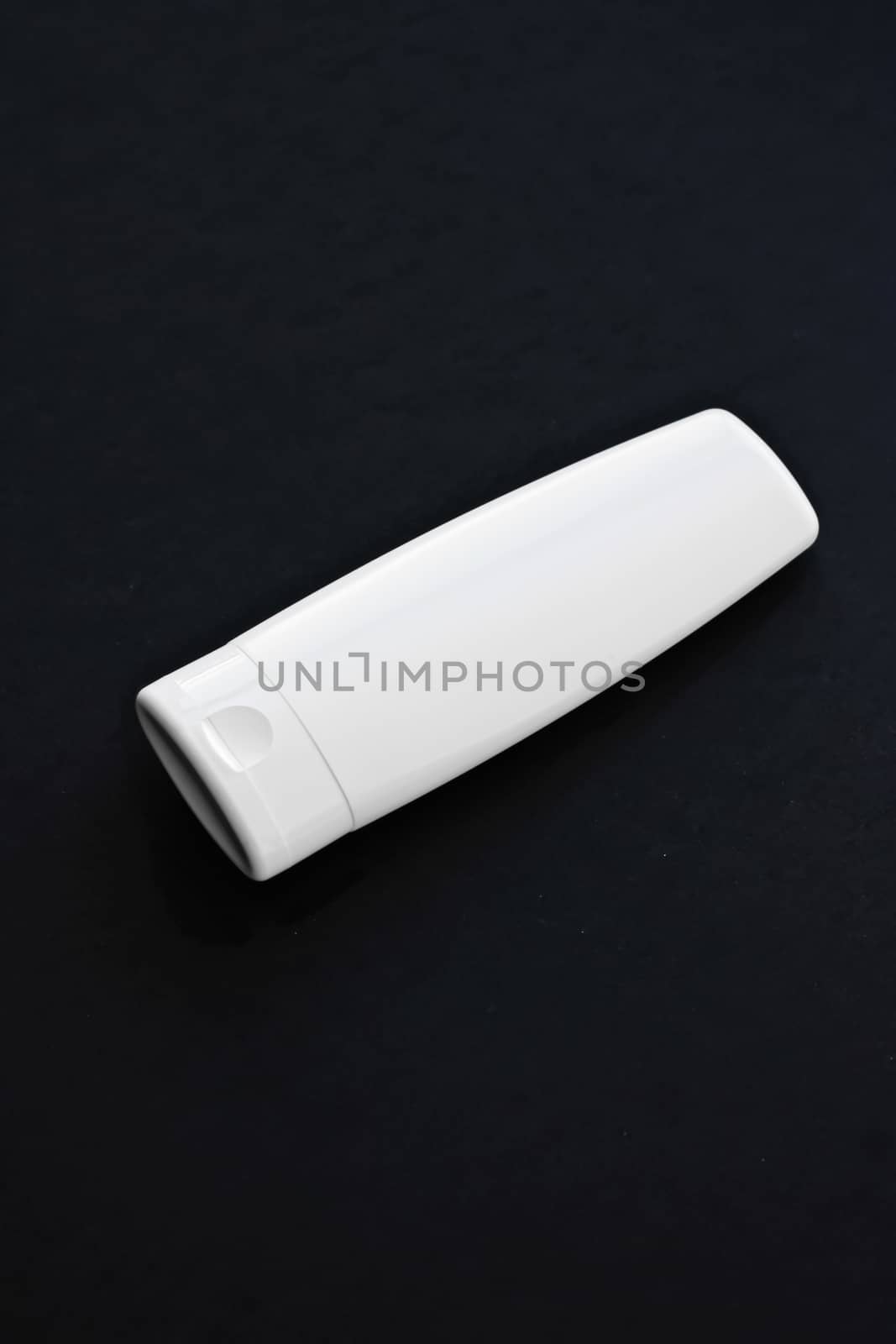 Blank label cosmetic container bottle as product mockup on black background, hygiene and healthcare