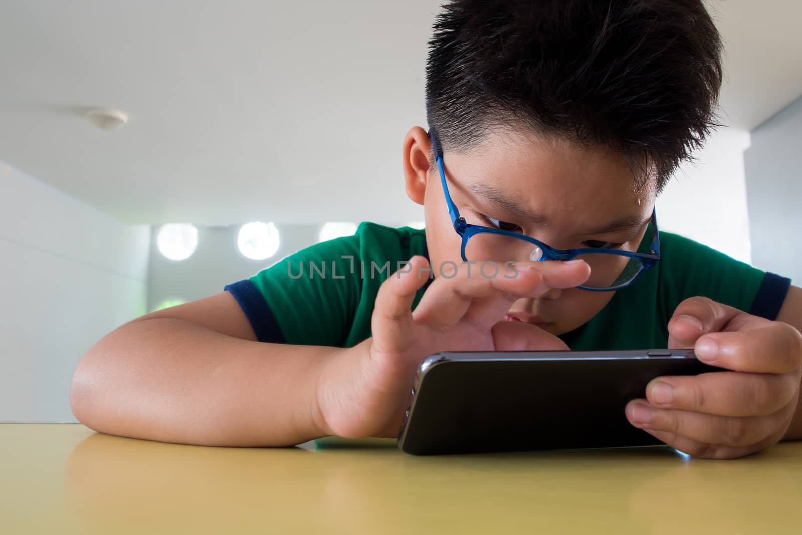 Close up serious asian boy playing on smartphone