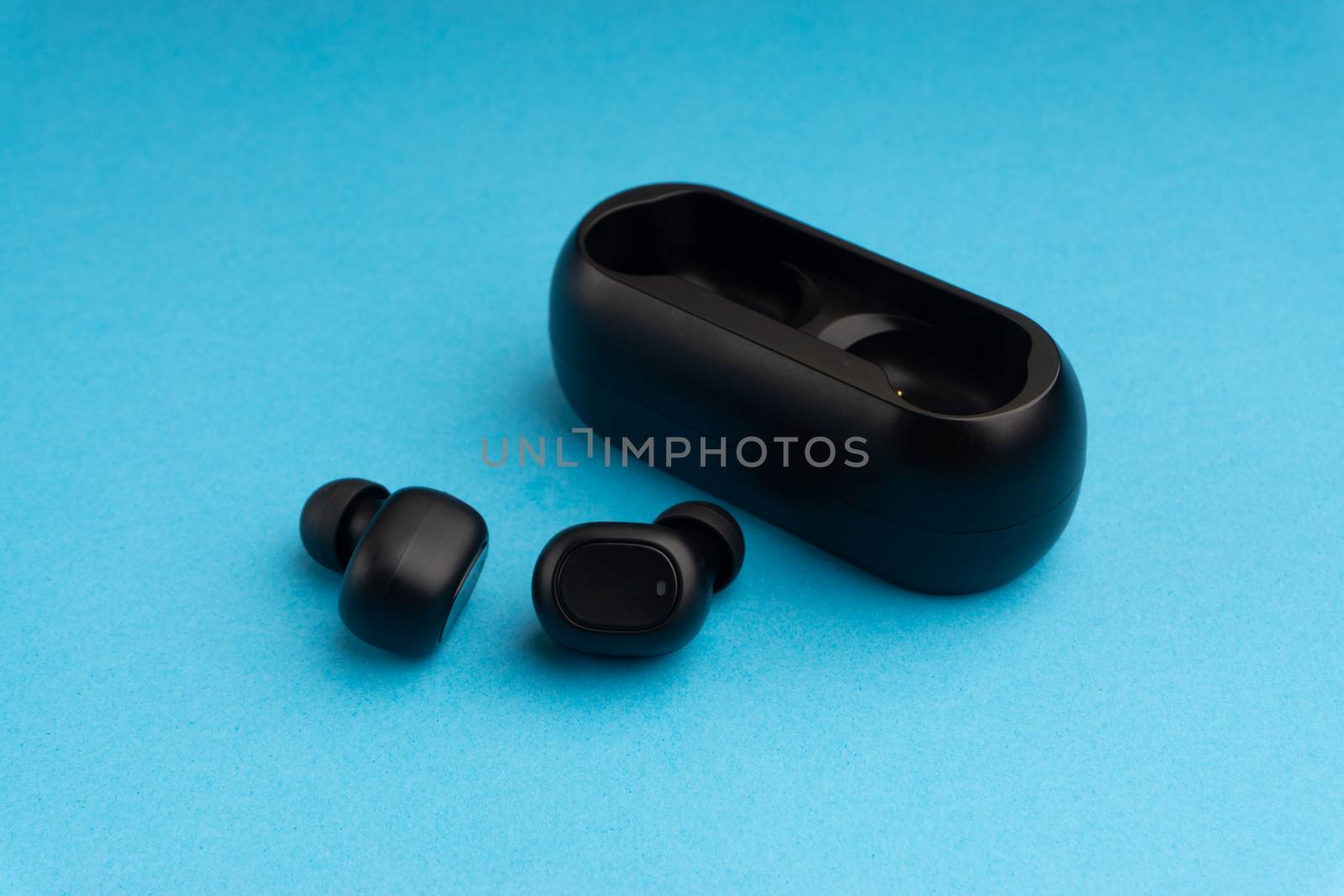 Wireless earbuds or earphones on blue background by silverwings