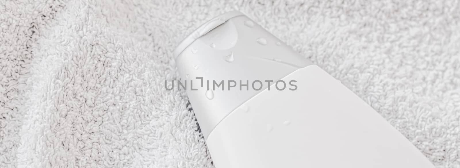 Blank label cosmetic container bottle as product mockup on white towel background, hygiene and healthcare