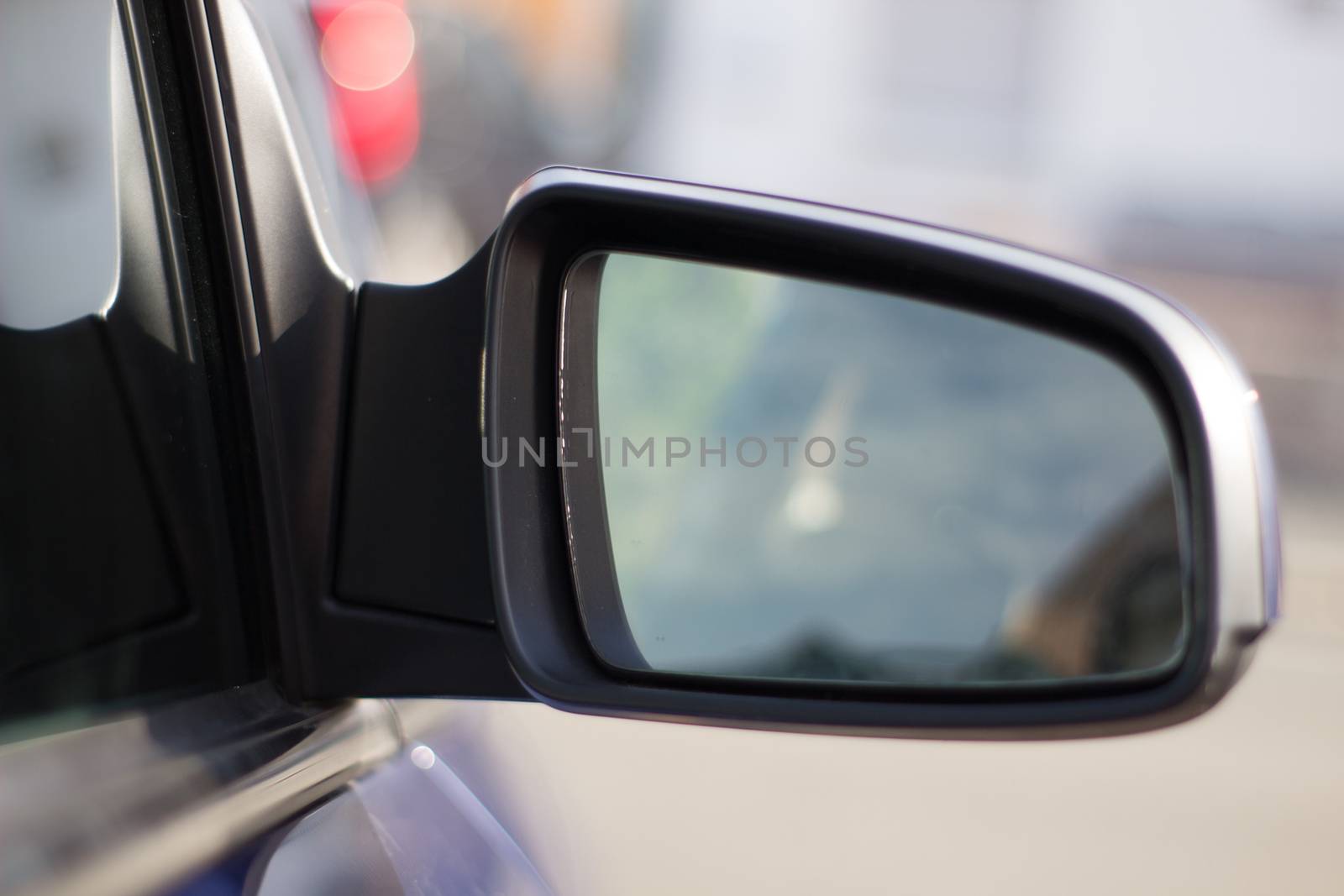Landscape in the sideview mirror of a speeding car
