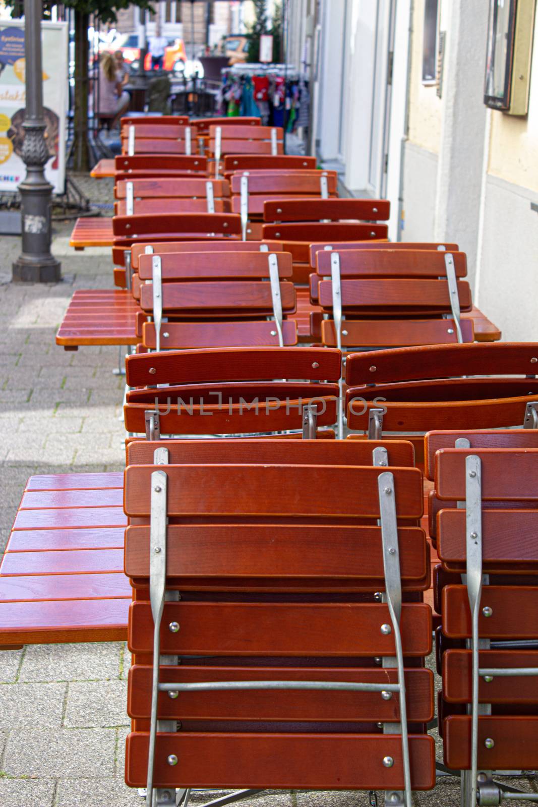 cafe street tables with chairs empty waiting for visitors arranges in structure red.