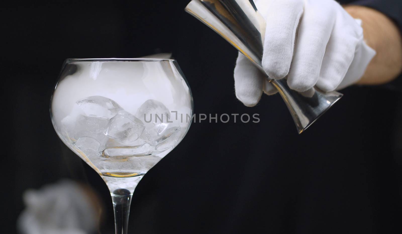 Close up drink with dry ice. Bartender preparing cocktail with dry ice in wine glass. The glass is wrapped in steam