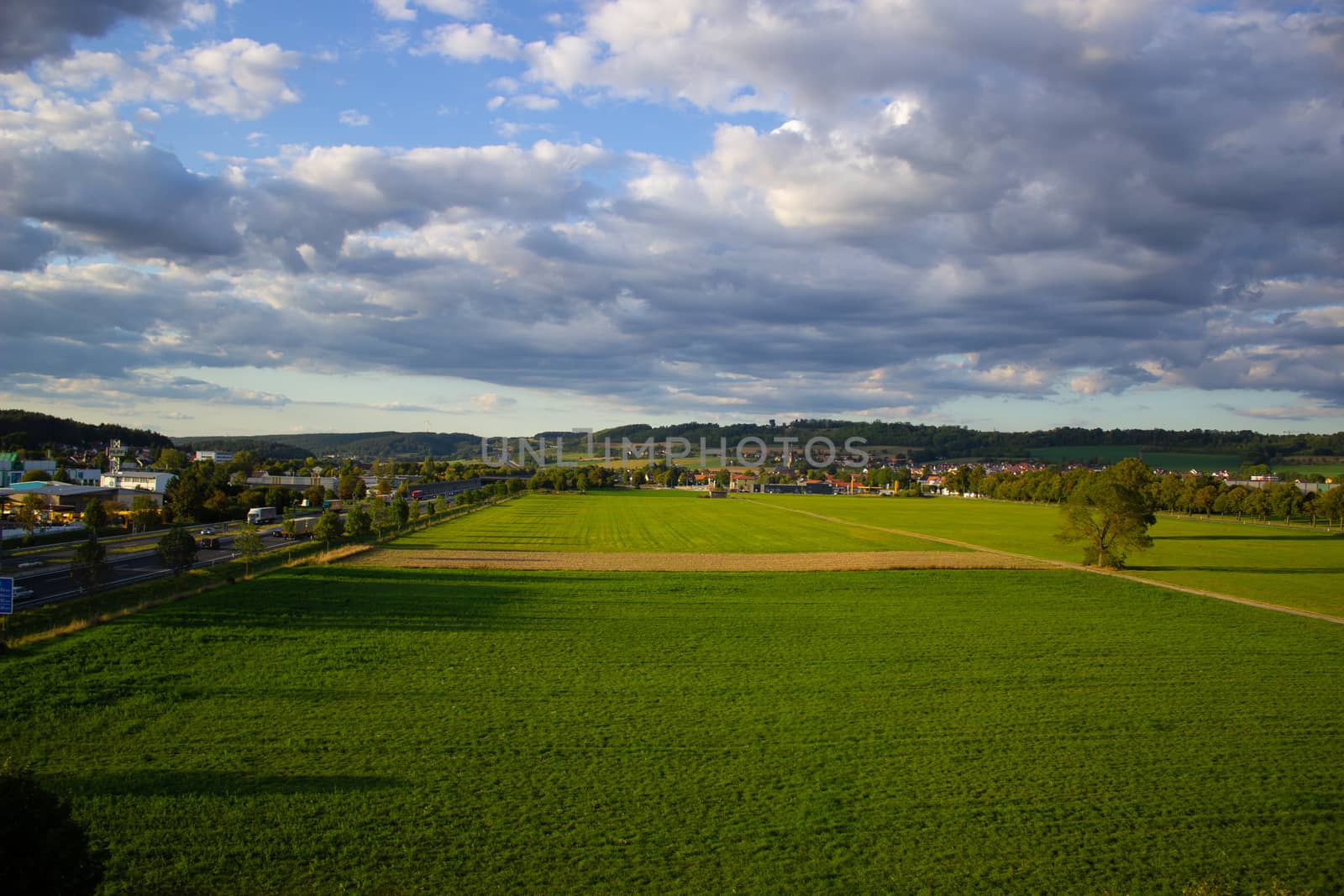 Big green field with blue sky. The view from the top