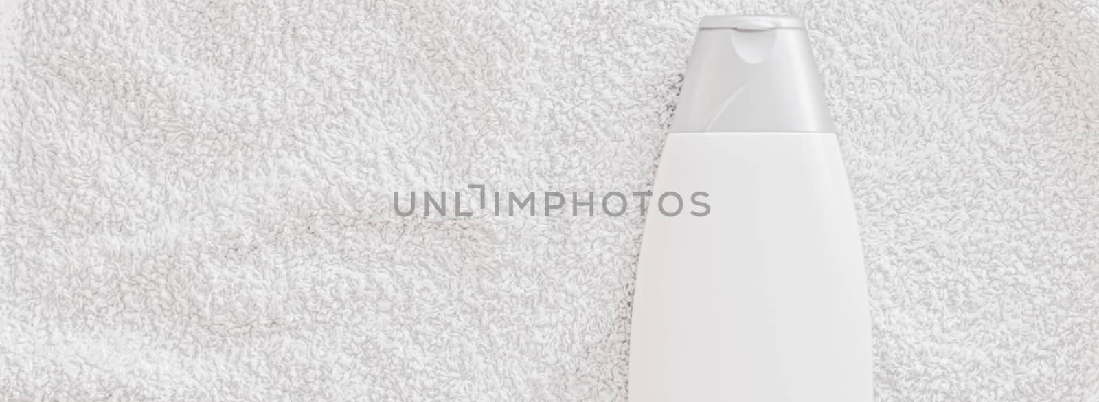 Blank label cosmetic container bottle as product mockup on white towel background, hygiene and healthcare