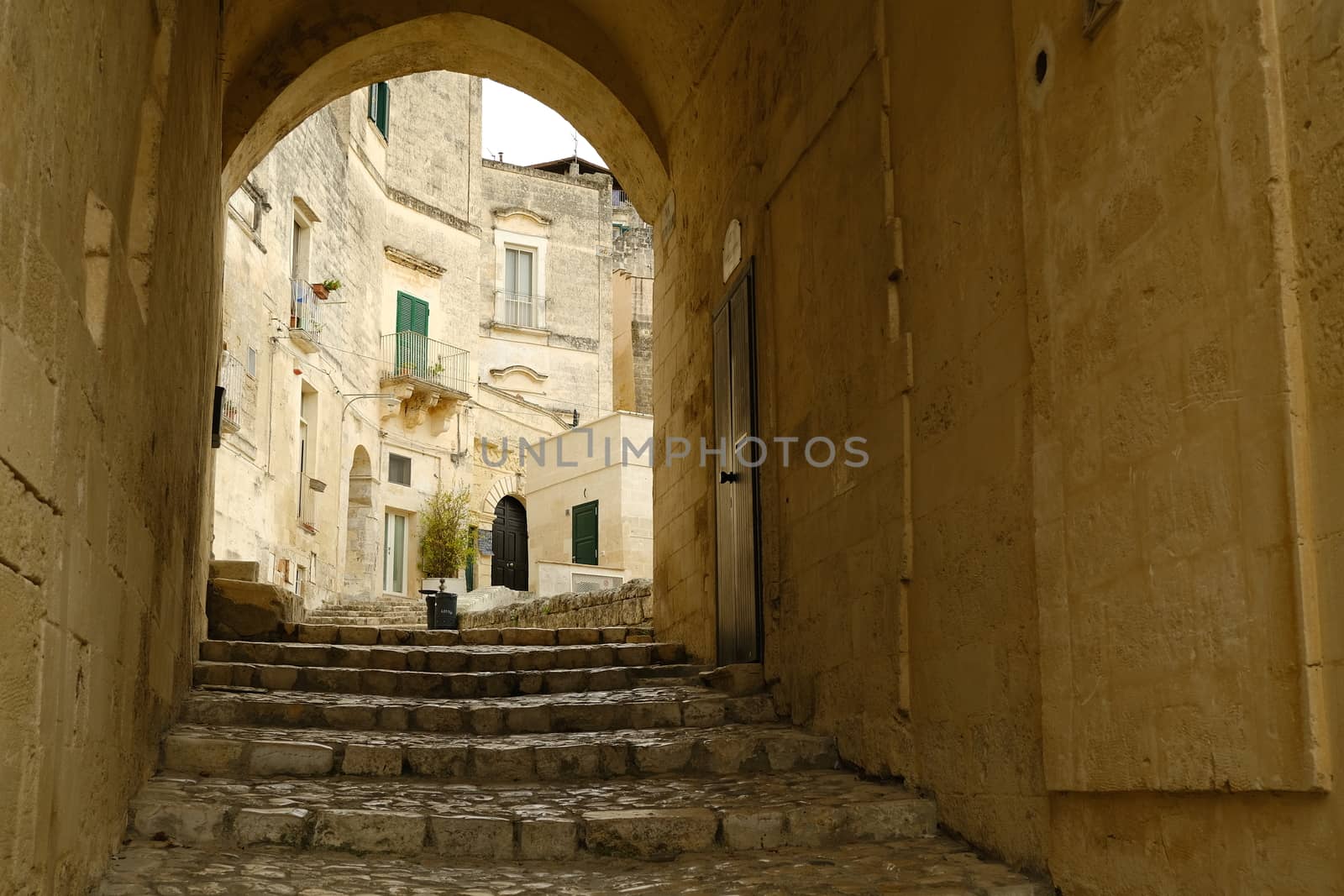 Matera, Basilicata, Italy. About 11/2019. Road in the ancient city of Matera. Paving with beige stone and covering with arch and vault.