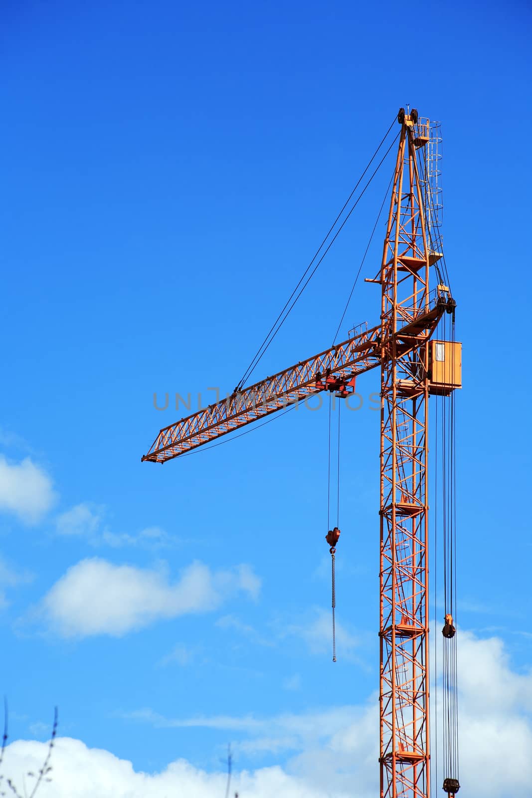 Industrial theme. Yellow construction crane against blue sky