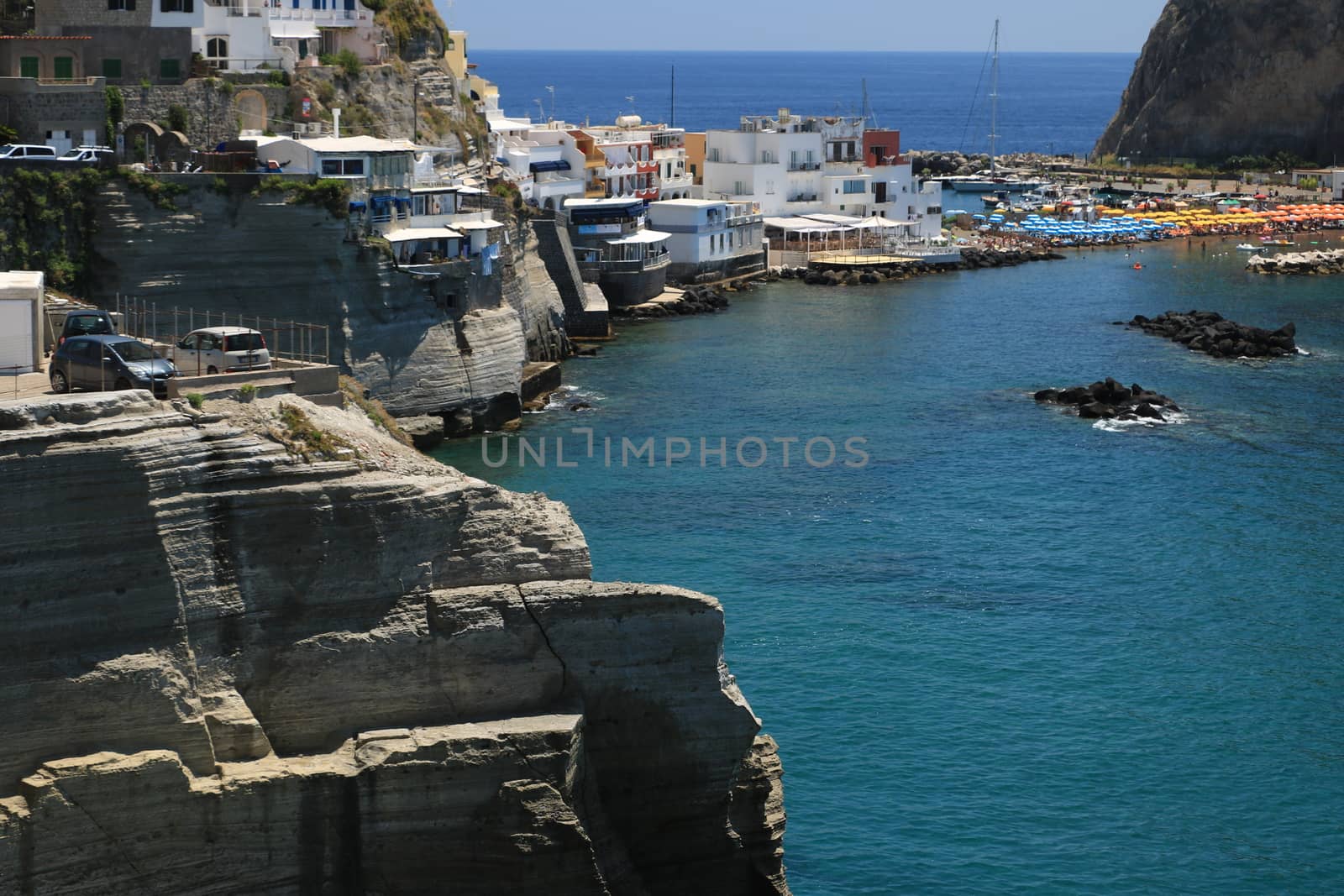 Sant'angelo di Ischia, Mediterranean sea near Naples. The mountain is connected to the mainland by a sandy beach with umbrellas.