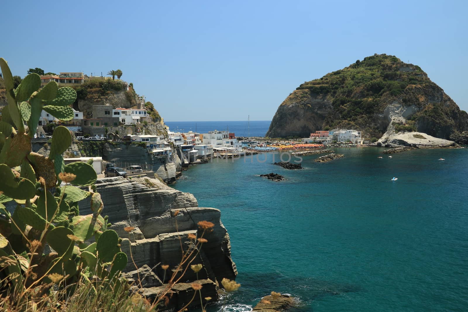 Sant'angelo di Ischia, Mediterranean sea near Naples. The mountain is connected to the mainland by a sandy beach with umbrellas.