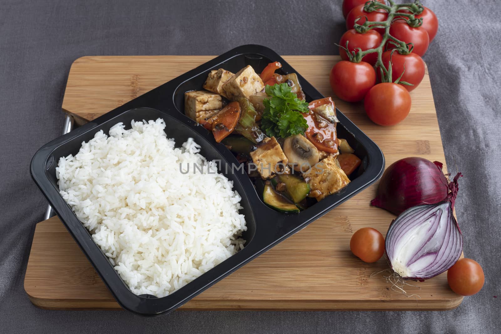 Stir fried toffu with vegetable served in a takeaway recipient