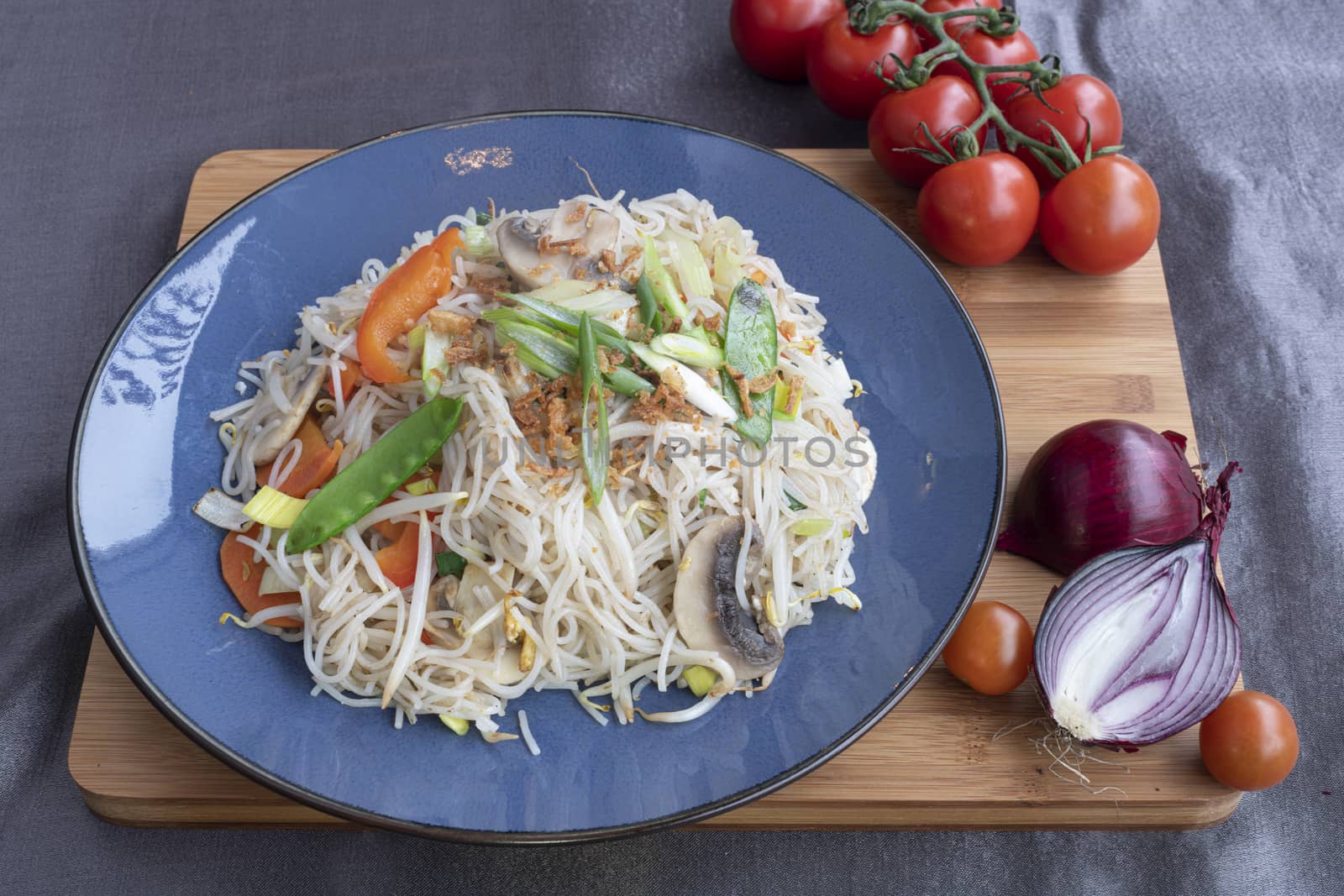 Chinese fried mee hoon, noodle  served with fresh vegetable and on a square white plate