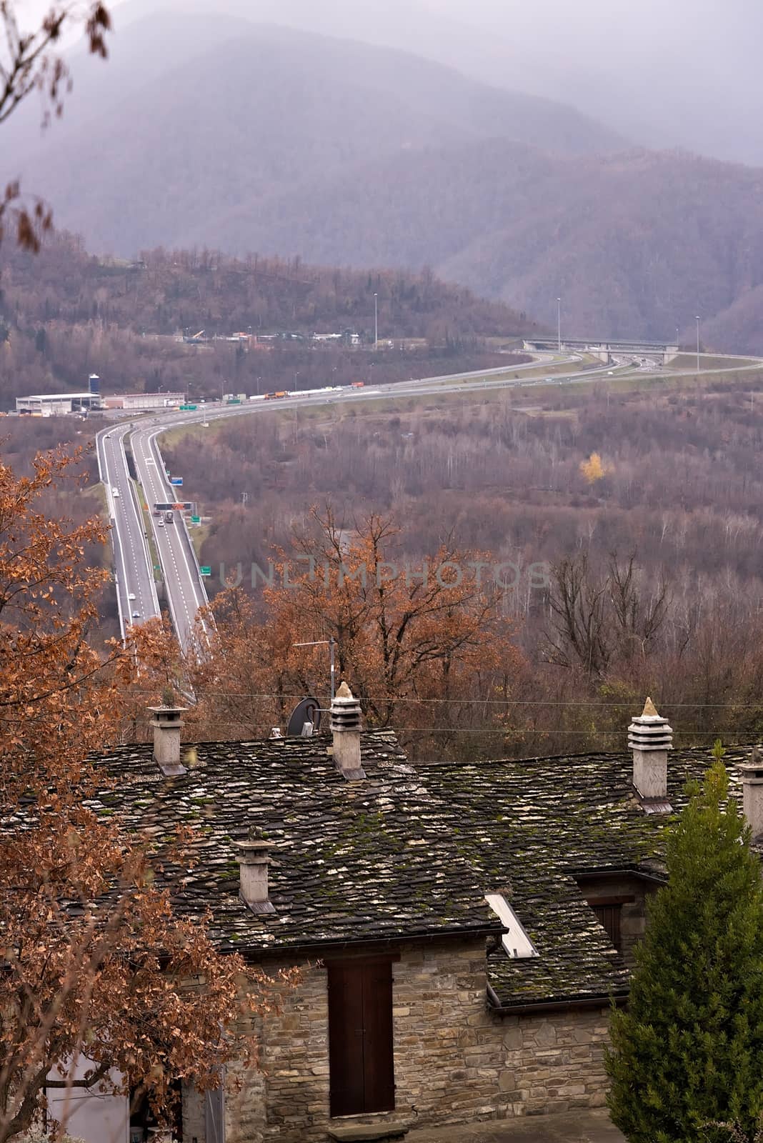 Parma, Emilia R. About 12/2015. Highway of the Cisa. Asphalt strip running through the mountains of Tuscany and Emilia. Stone house and trees with yellow leaves.
