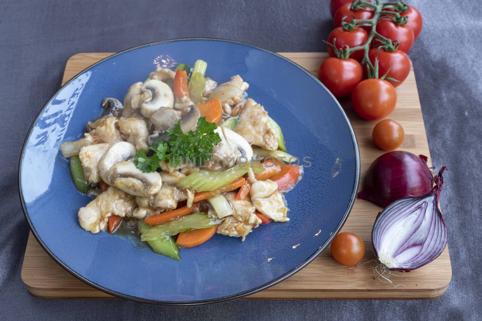 Stir fried chicken with white rice and vegetable served on a blue plate