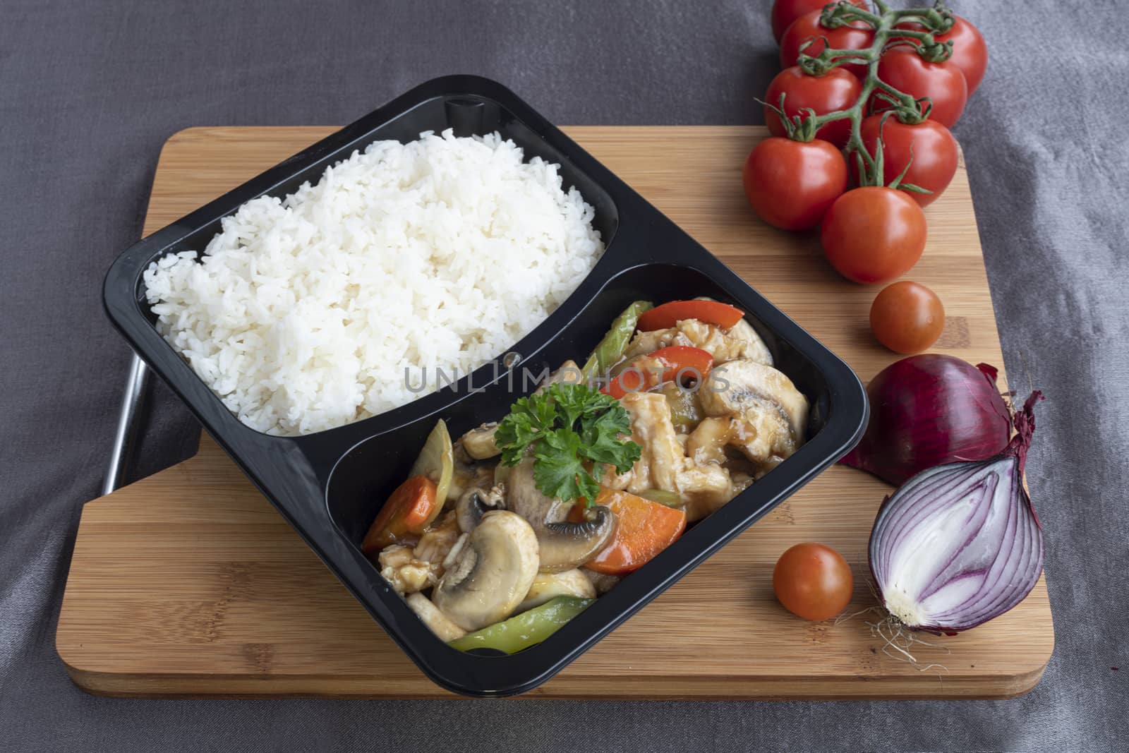 Stir fried chicken with white rice and vegetable served in a recipent for take away
