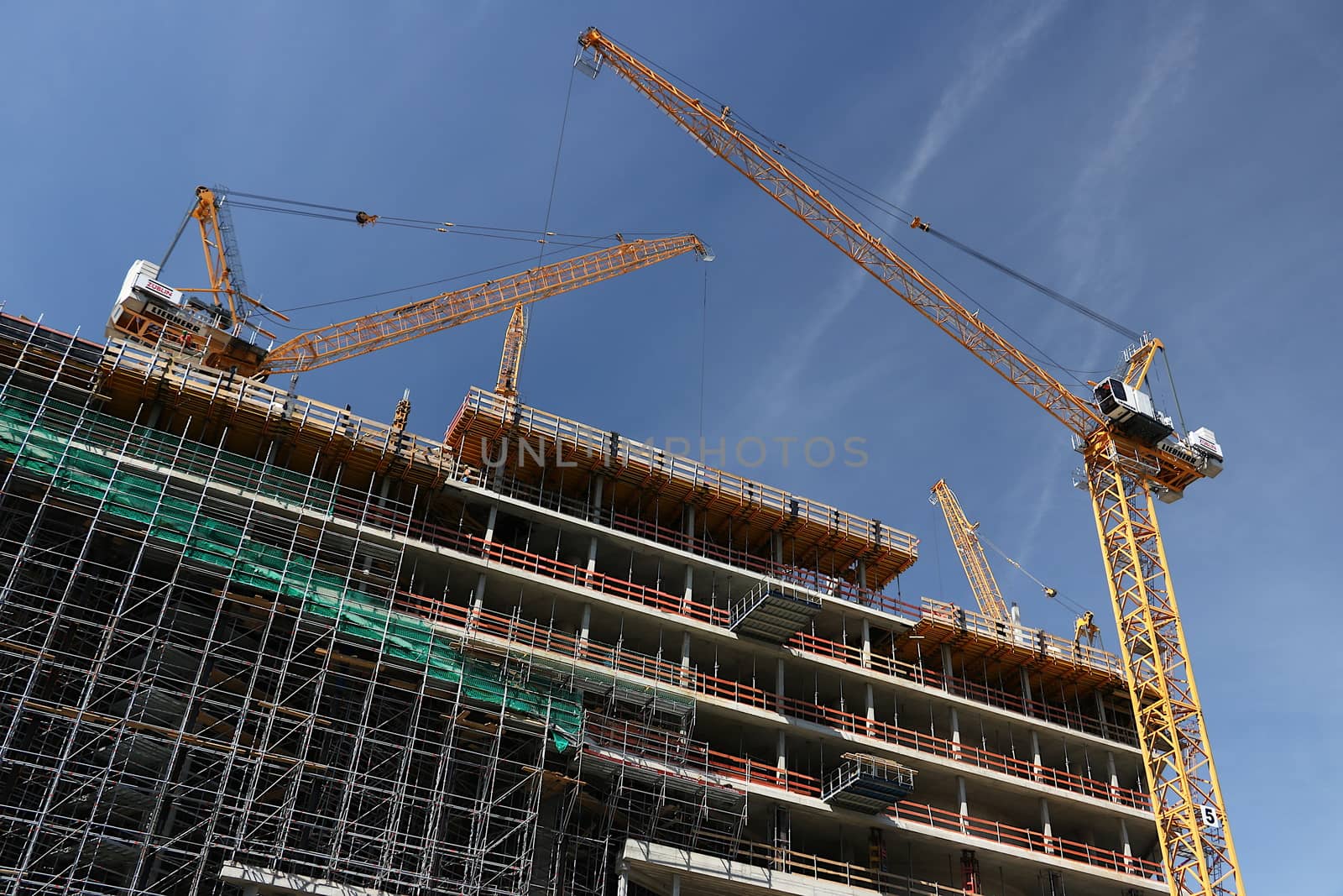 Scaffolding and cranes on a construction site. Cranes and scaffolding