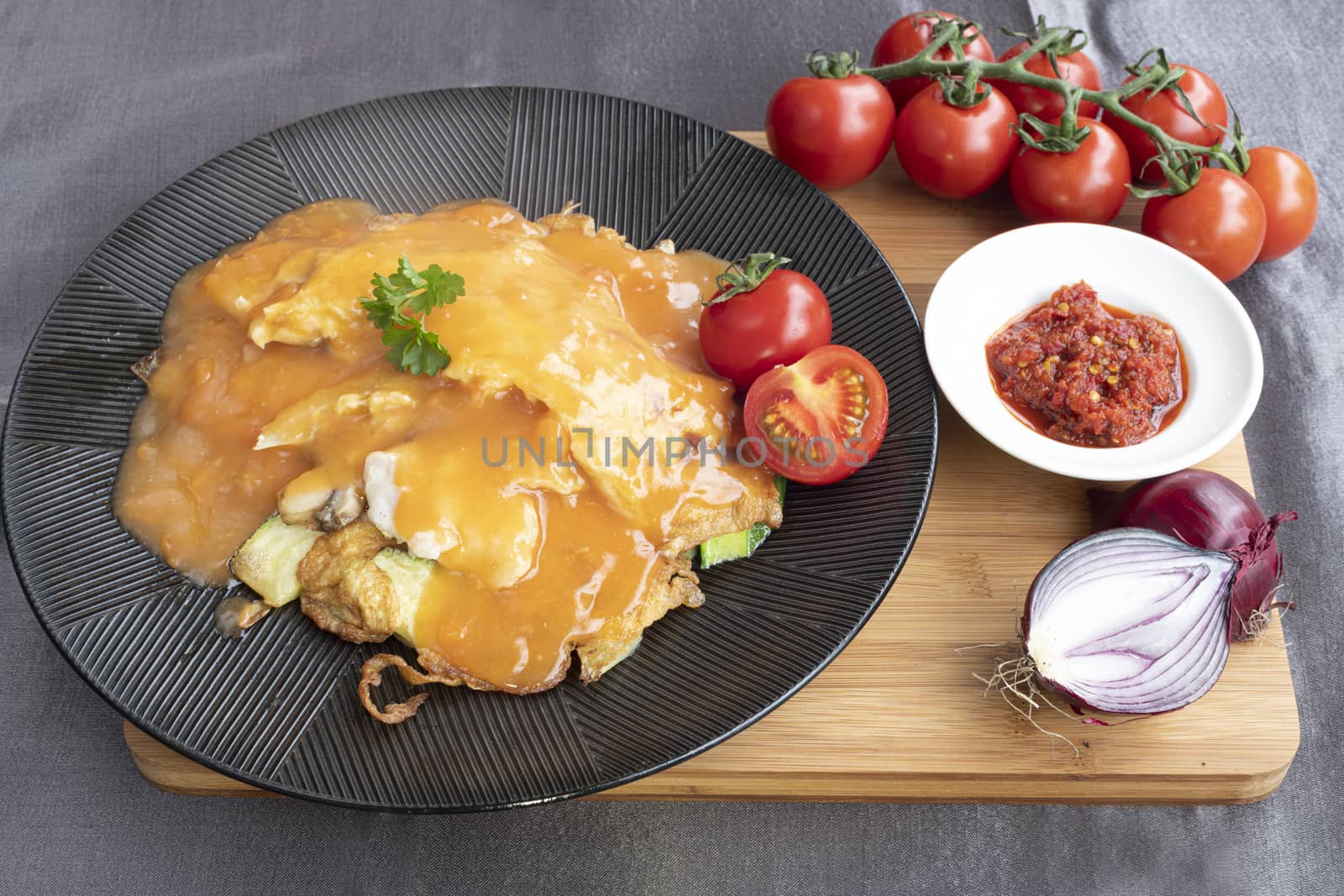 Omelet served with several type of vegetables and tomatoe sauce
