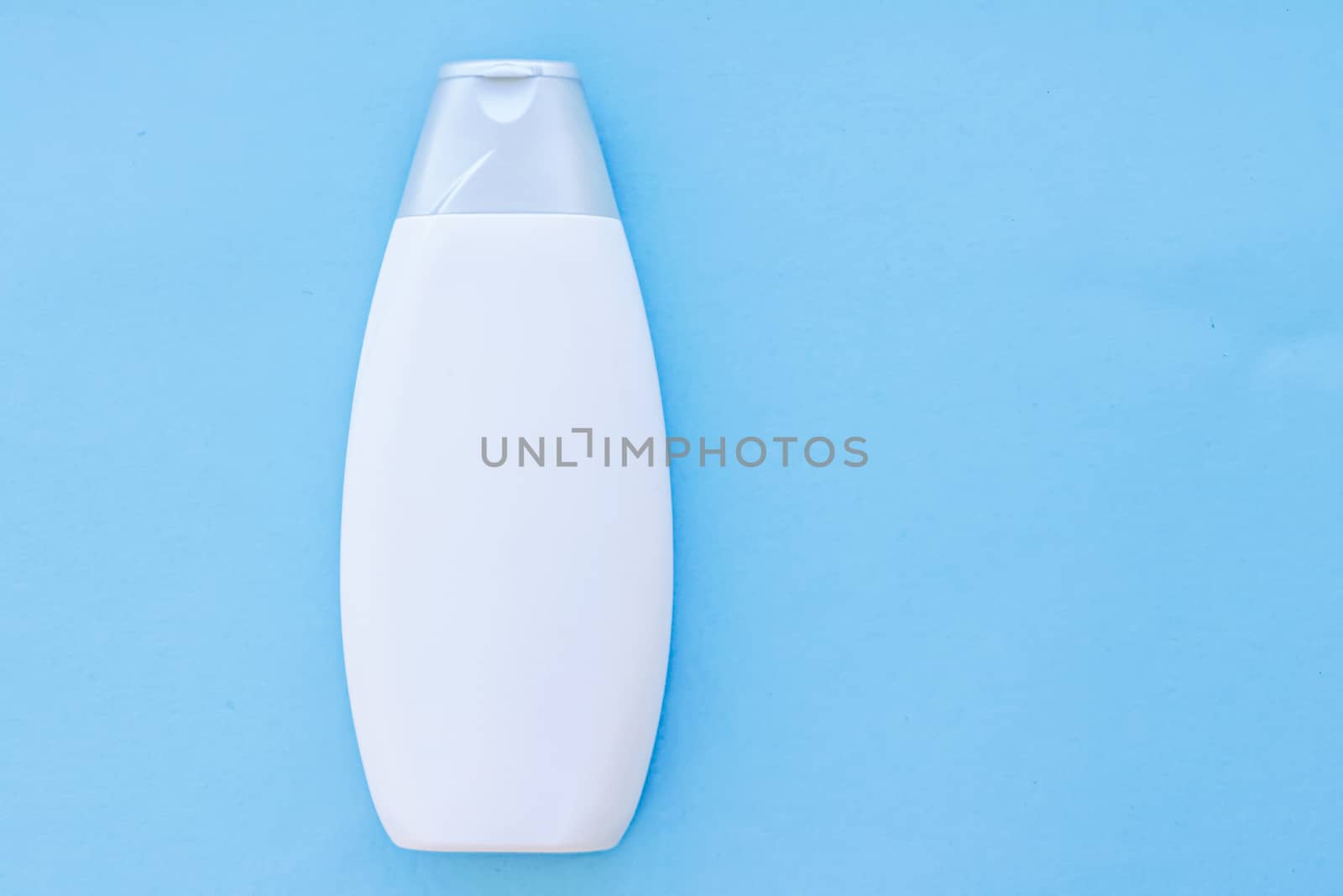 Blank label cosmetic container bottle as product mockup on blue background by Anneleven