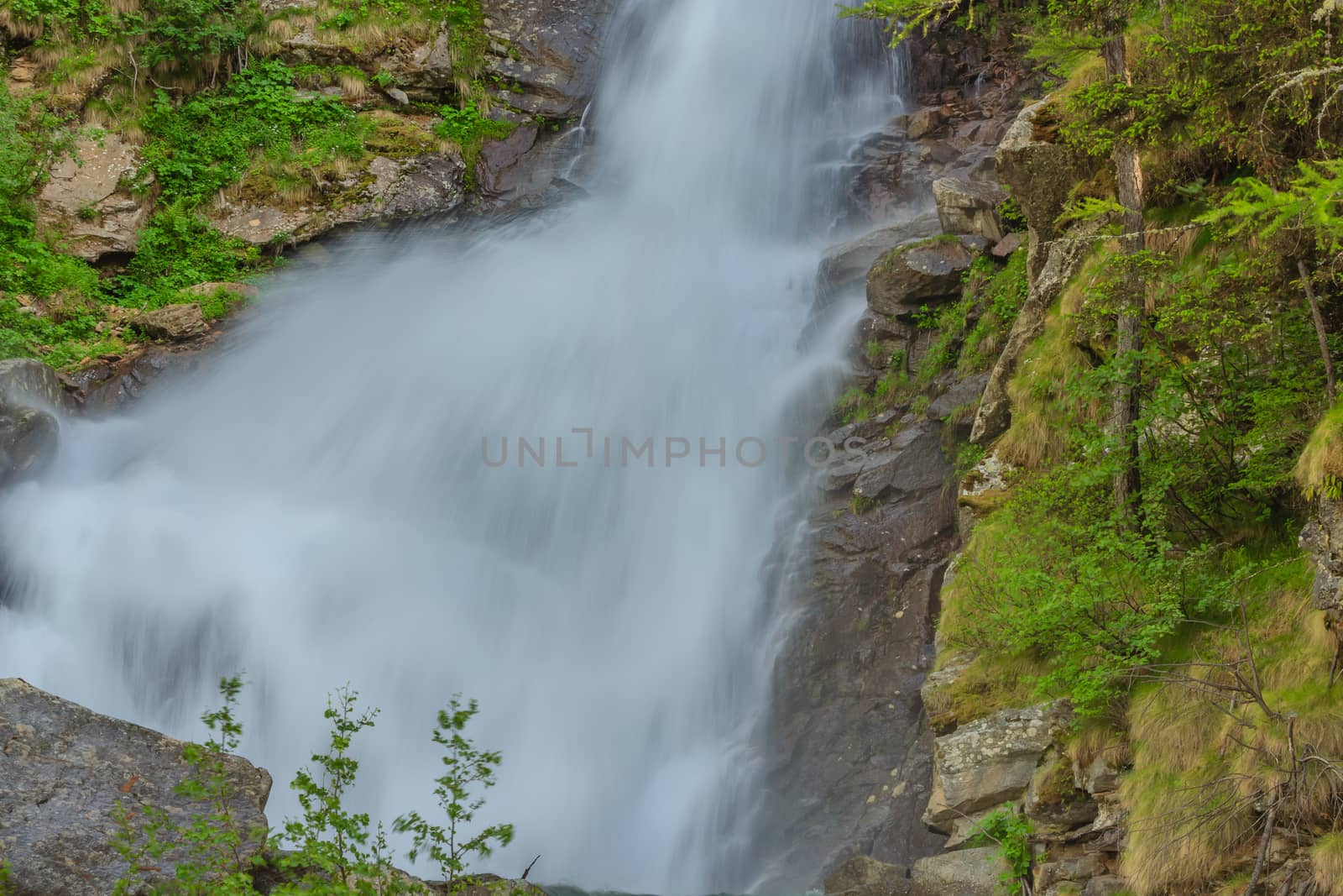 an imposing waterfall falls impetuous from the glaciers in the National Park of Great Paradise,in Piedmont,Italy