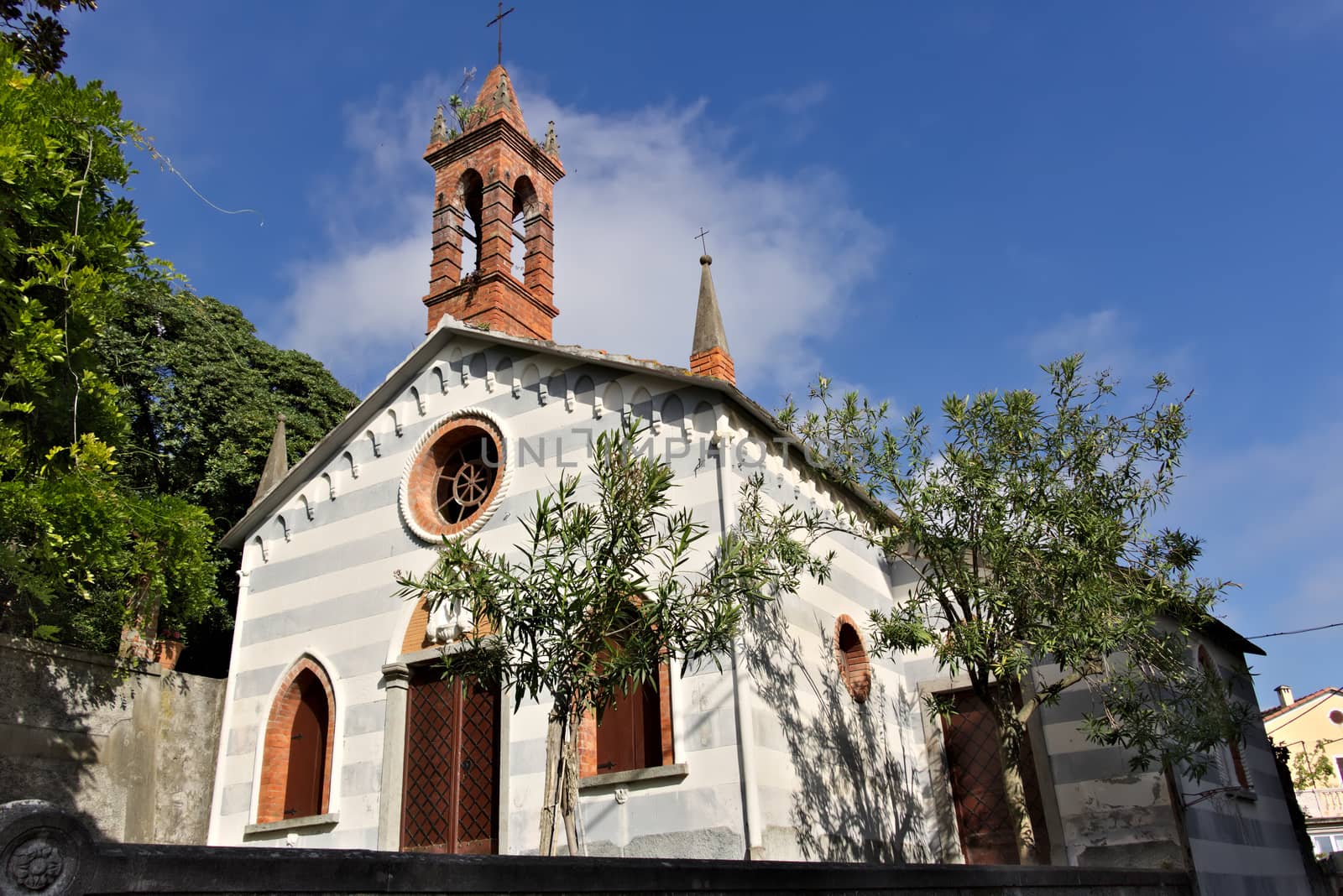 Small church in the village of Framura, near the Cinque Terre. Genoese neo-Gothic style of a small church with a brick bell tower.