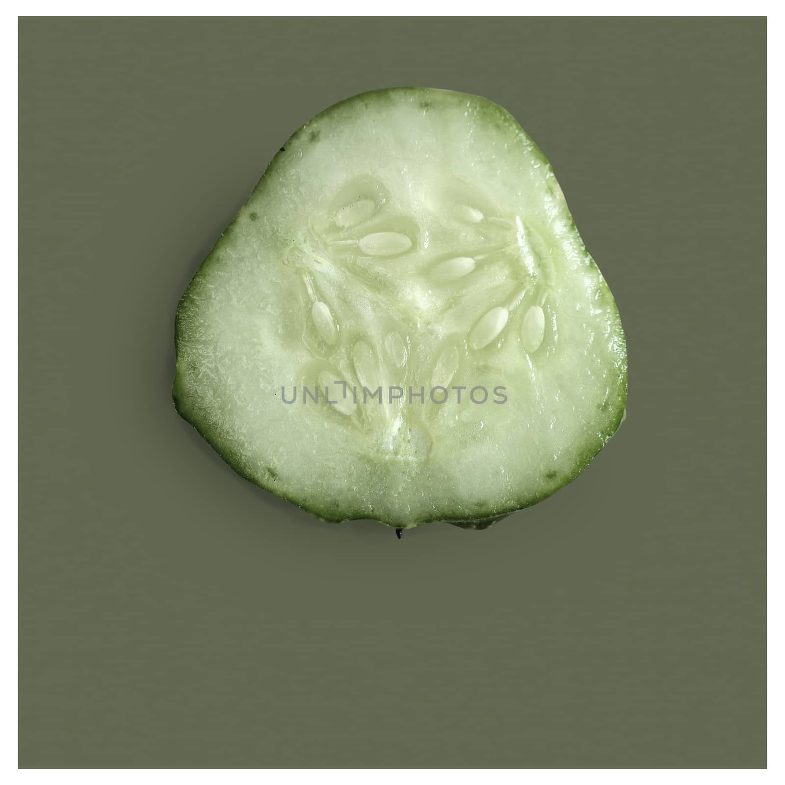 On a green background, cross-section of cucumber, top view, close-up. Healthy food concept, natural product.