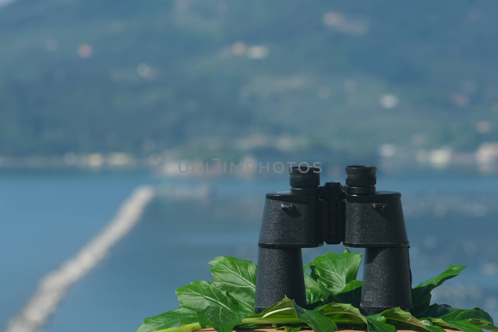 Binoculars resting on a table. Ligurian Mediterranean sea in the Gulf of La Spezia.