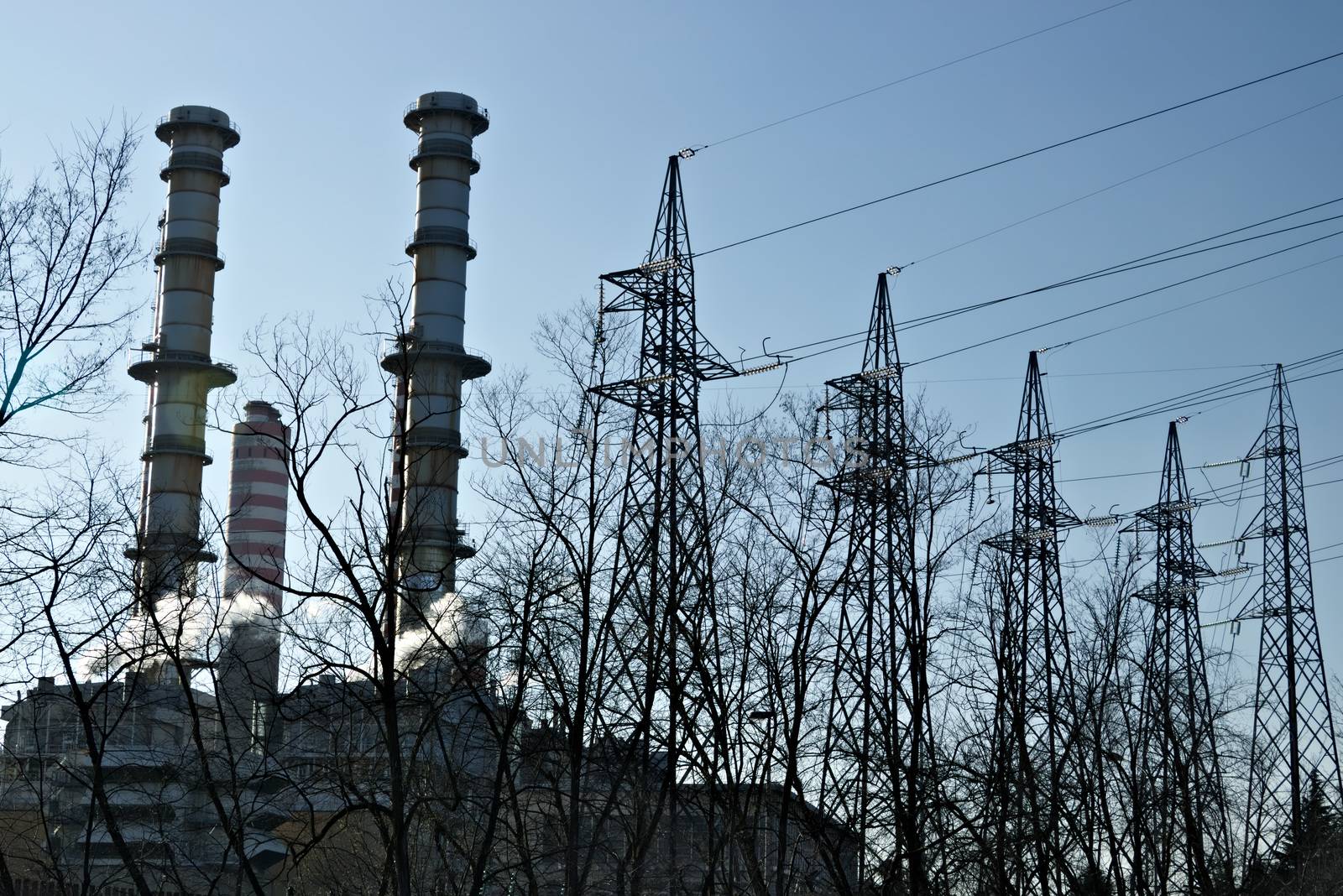 The Turbigo power plant, 40 km from Milan, owned by Iren is located along the Naviglio Grande. The video shows steam puffs coming out of the central, behind the tall chimneys.  The shot goes from the chimneys and pylons to the view of the dry river bed of the Naviglio that flows nearby.