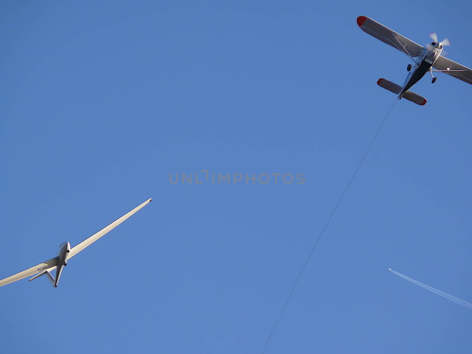 Glider pulled by a motorized plane. Glider airplane stands out f by Paolo_Grassi