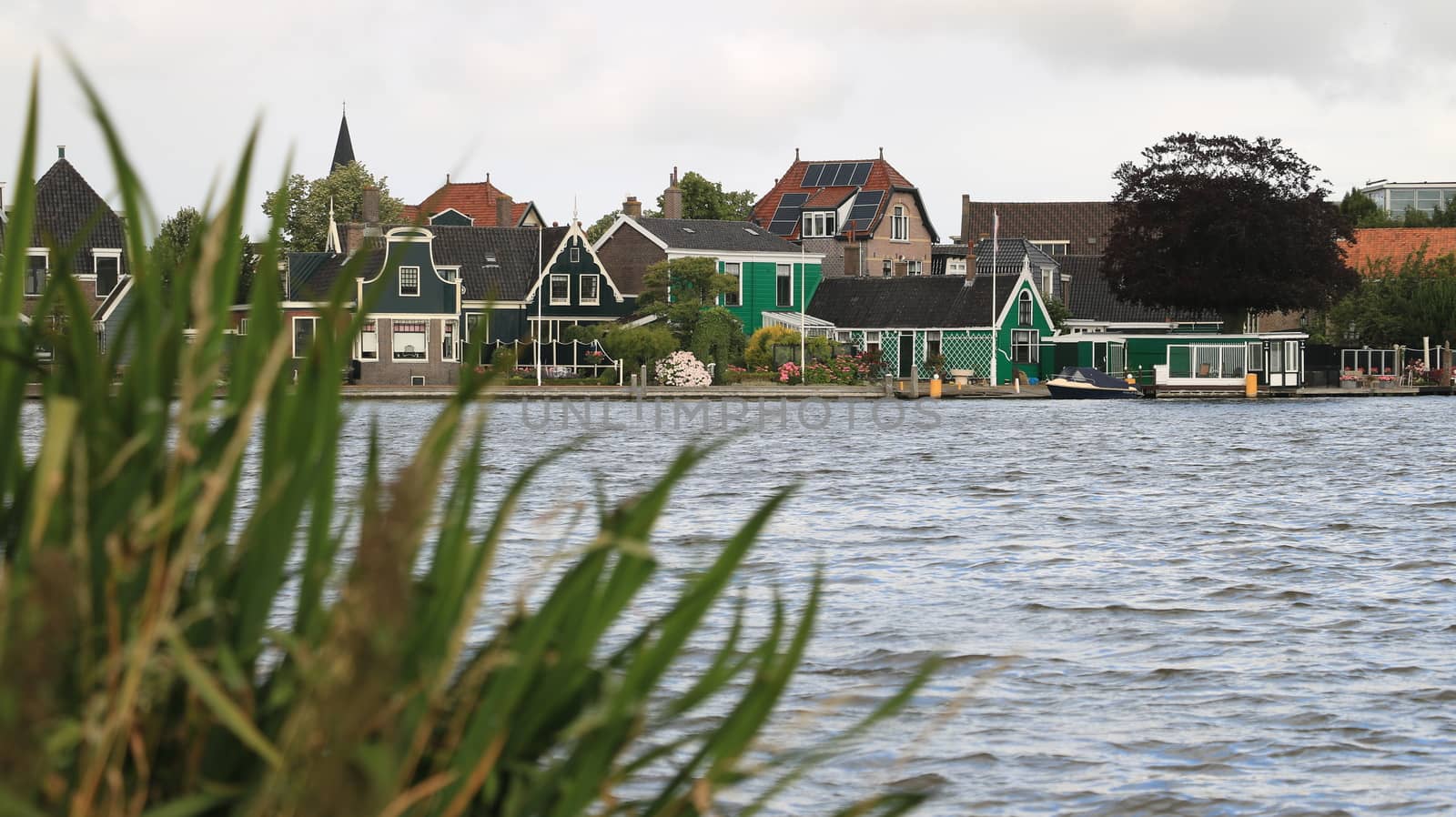 Typical Dutch houses on the canal near Amsterdam. In the land of windmills there are many traditional houses along the river.