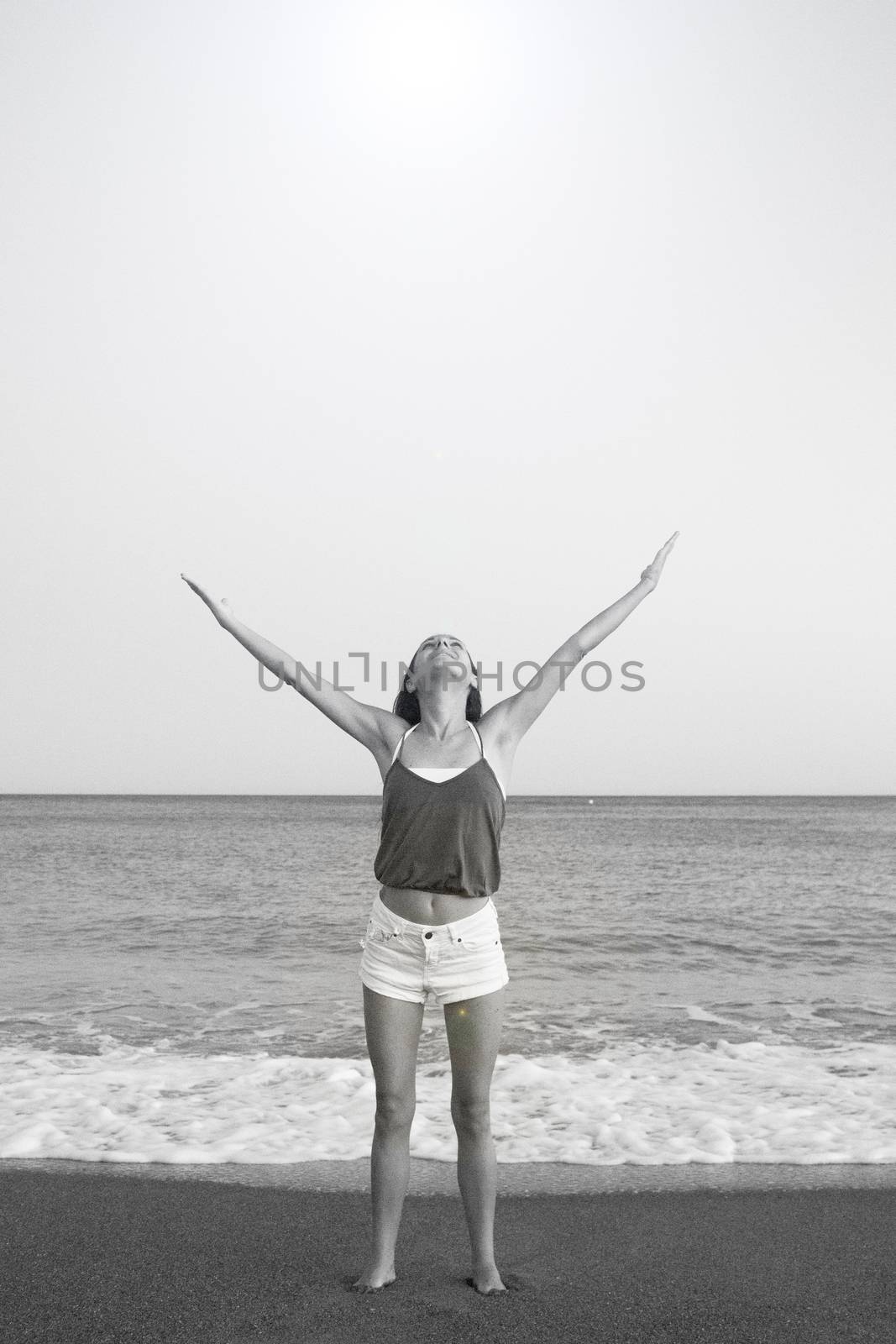 Mujer joven en la playa en actitud muy positiva y feliz. Precioso atardecer