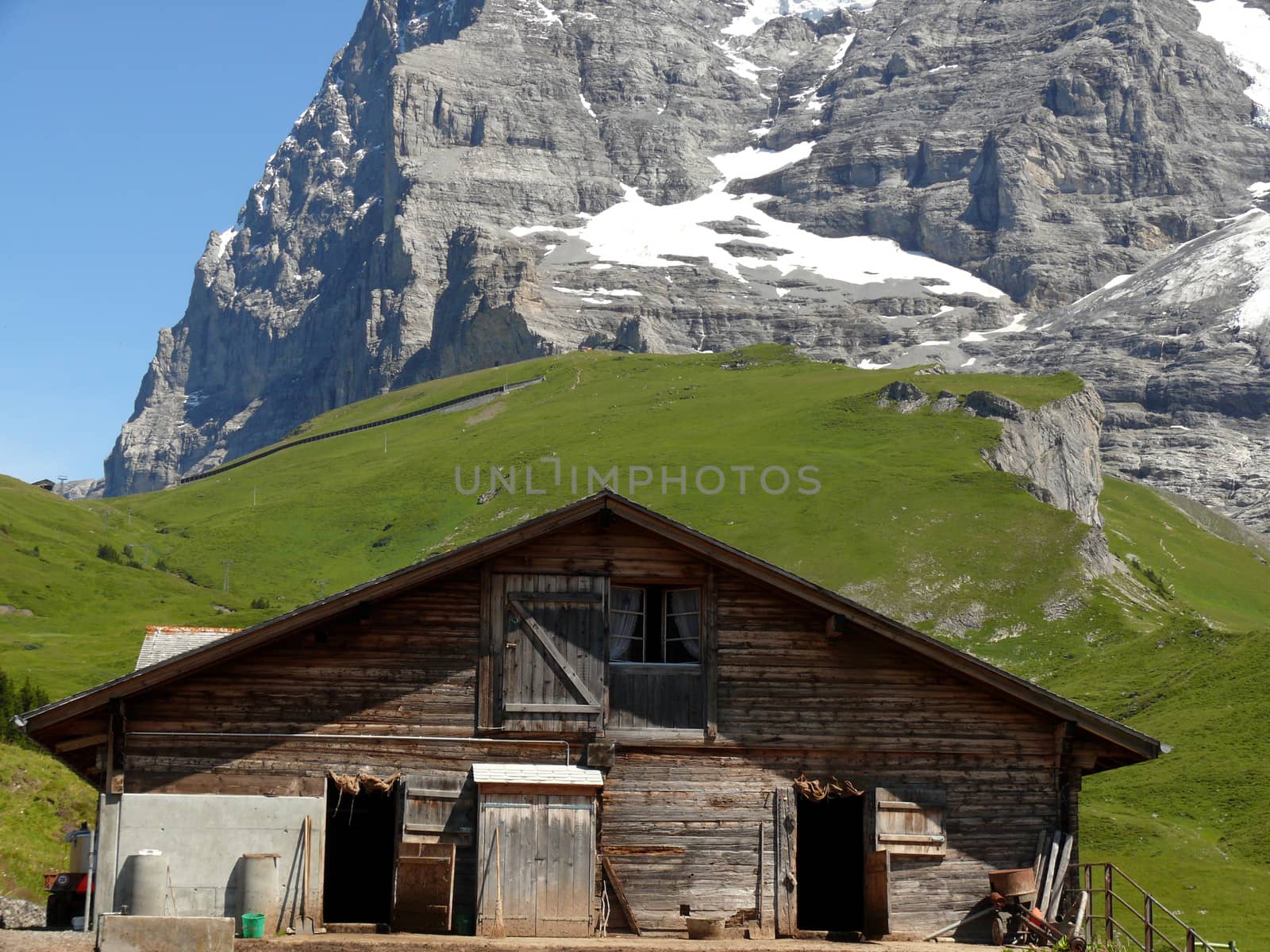 A mountain hut and the Swiss Alps in the background. by Paolo_Grassi