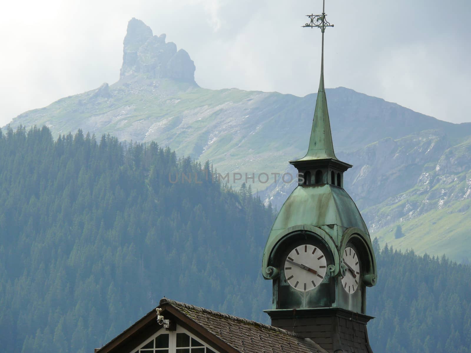 A mountain top and in the foreground the bell tower with the clock.  08/04/2009.