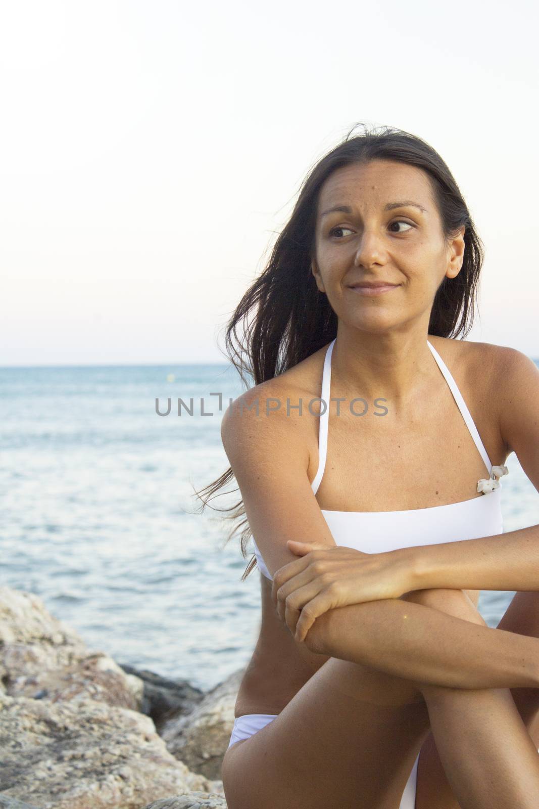 Portrait of young woman with sunset on the beach. Positive, relaxed and calm attitude