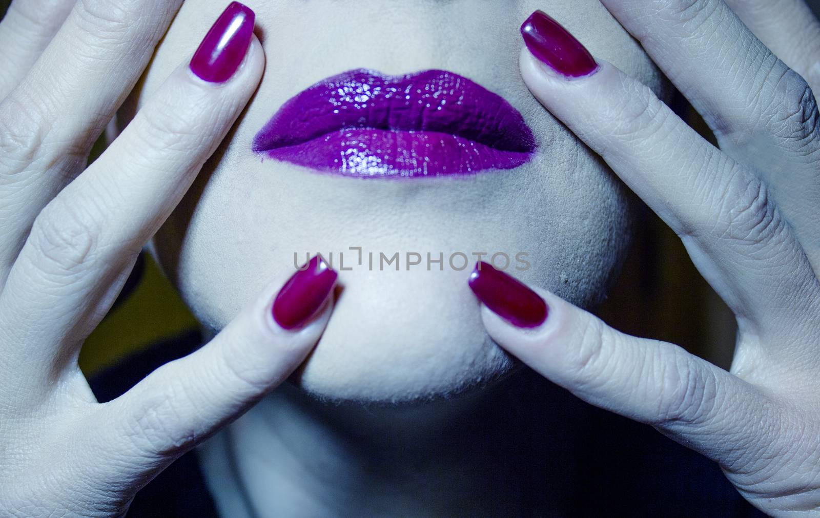 Portrait of woman with hand over face. Red makeup lips and nails