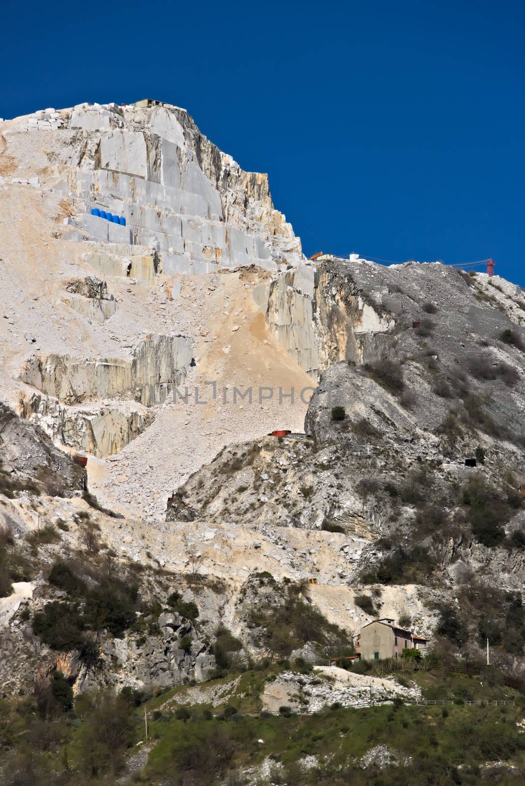 The precious white Carrara marble has been extracted from the Alpi Apuane quarries since Roman times. Today workers are helped by mechanical equipment (excavators, diamond wire machines and transport trucks).