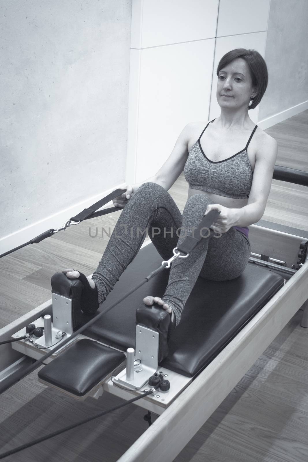 Woman doing pilates machine. Exercises to stretch the muscles by GemaIbarra