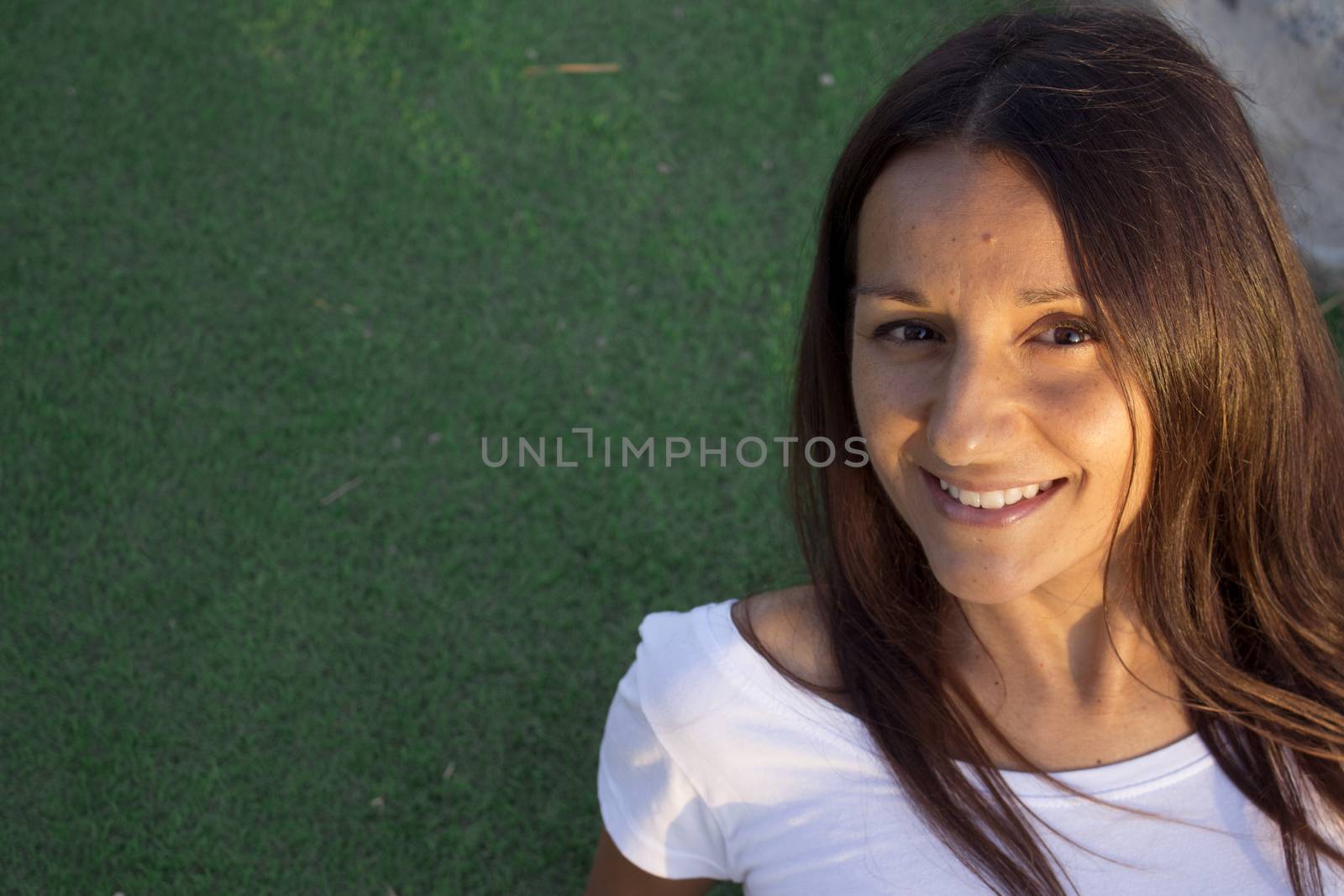 Portrait of young woman with happy expression. Green background