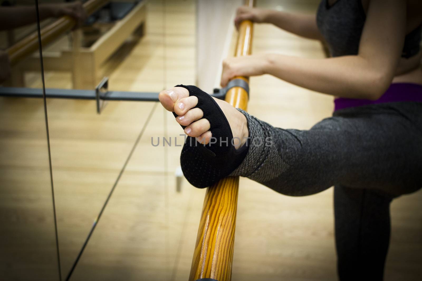 Female dancer doing leg stretches on the ballet barre