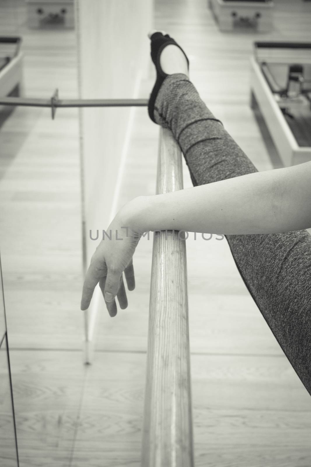 Female dancer doing leg stretches on the ballet barre