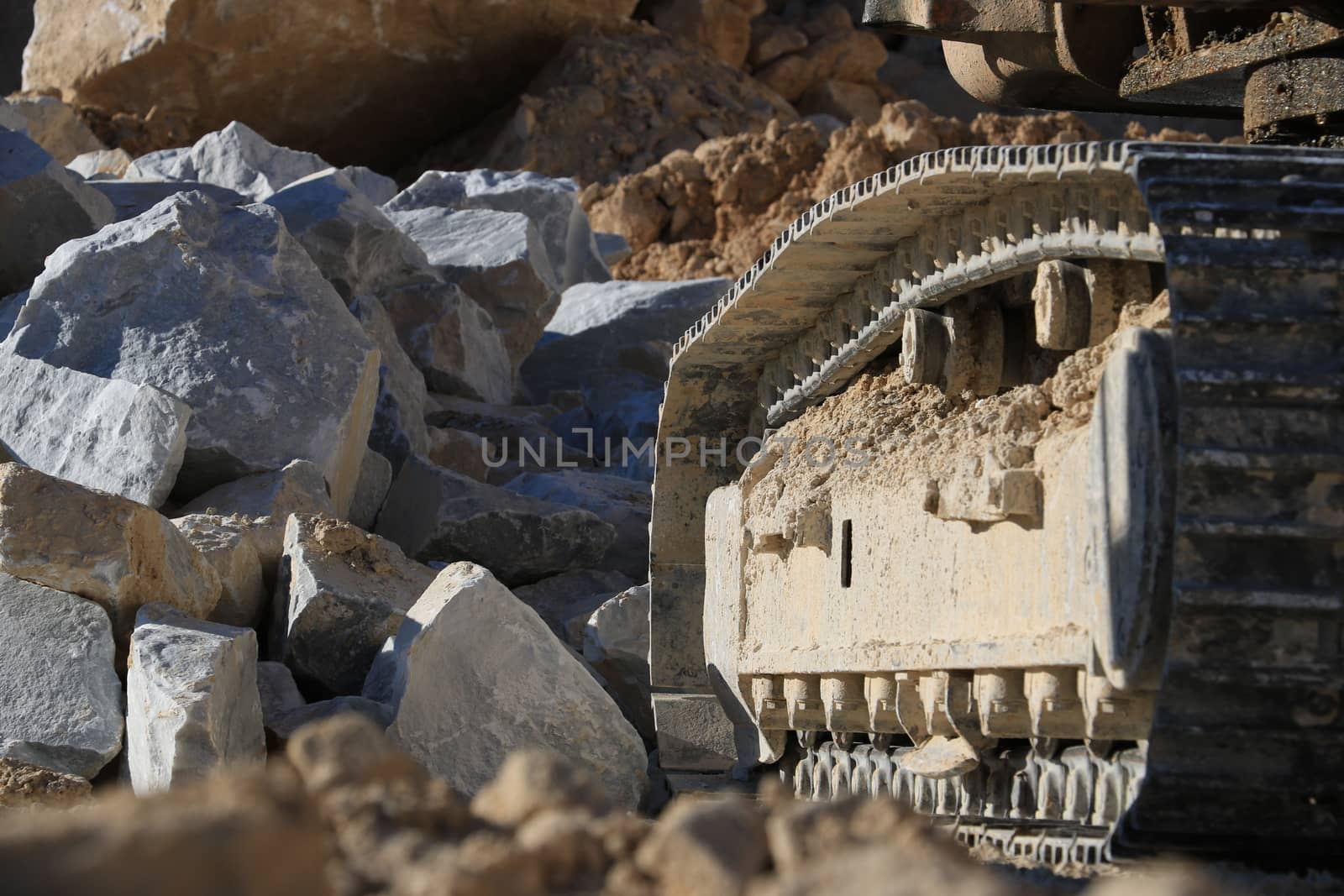 Excavator tracks in a marble quarry. Large excavators help men to extract white Carrara marble.