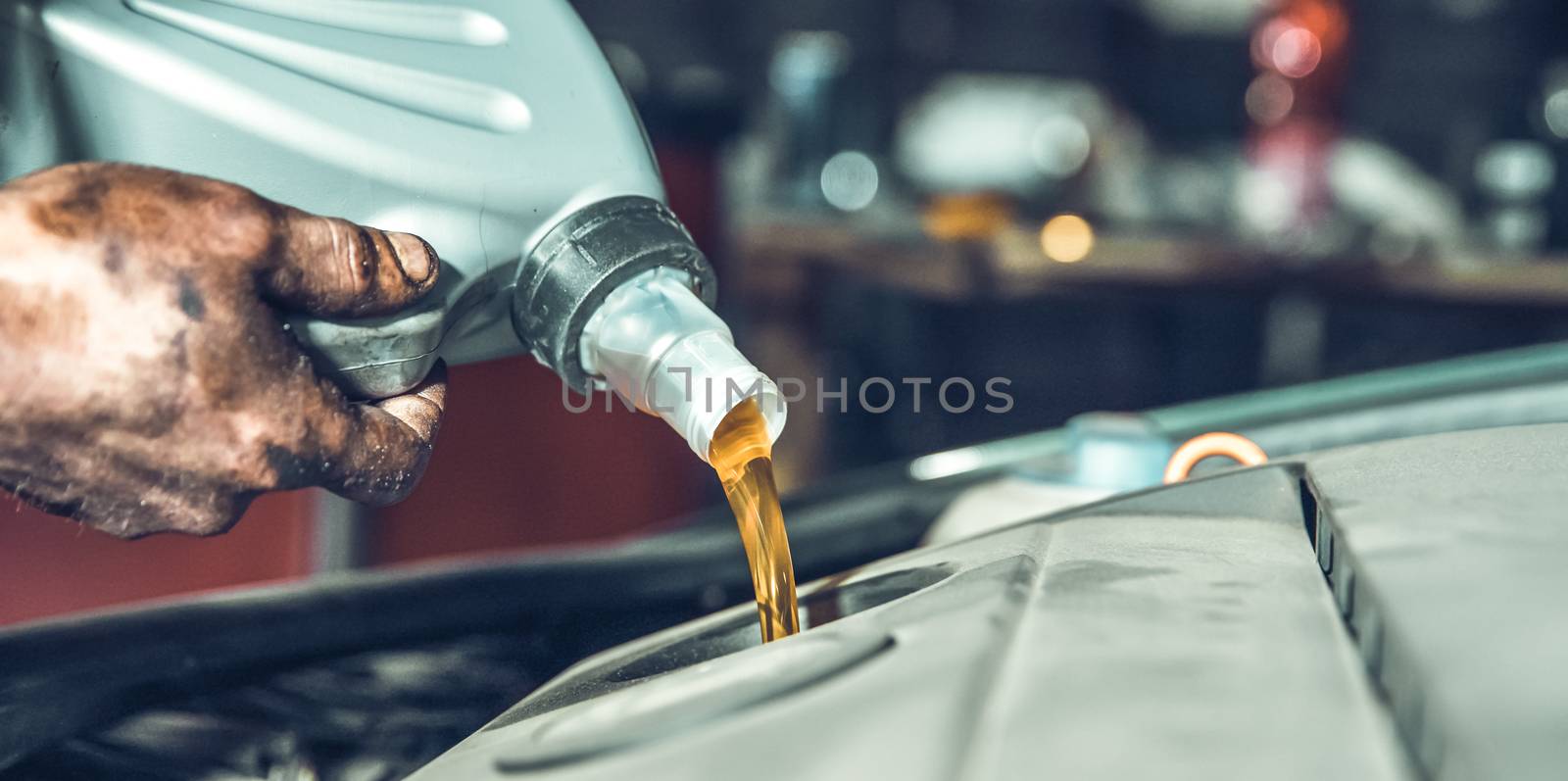 pouring new oil into the car engine from the canister during replacement.