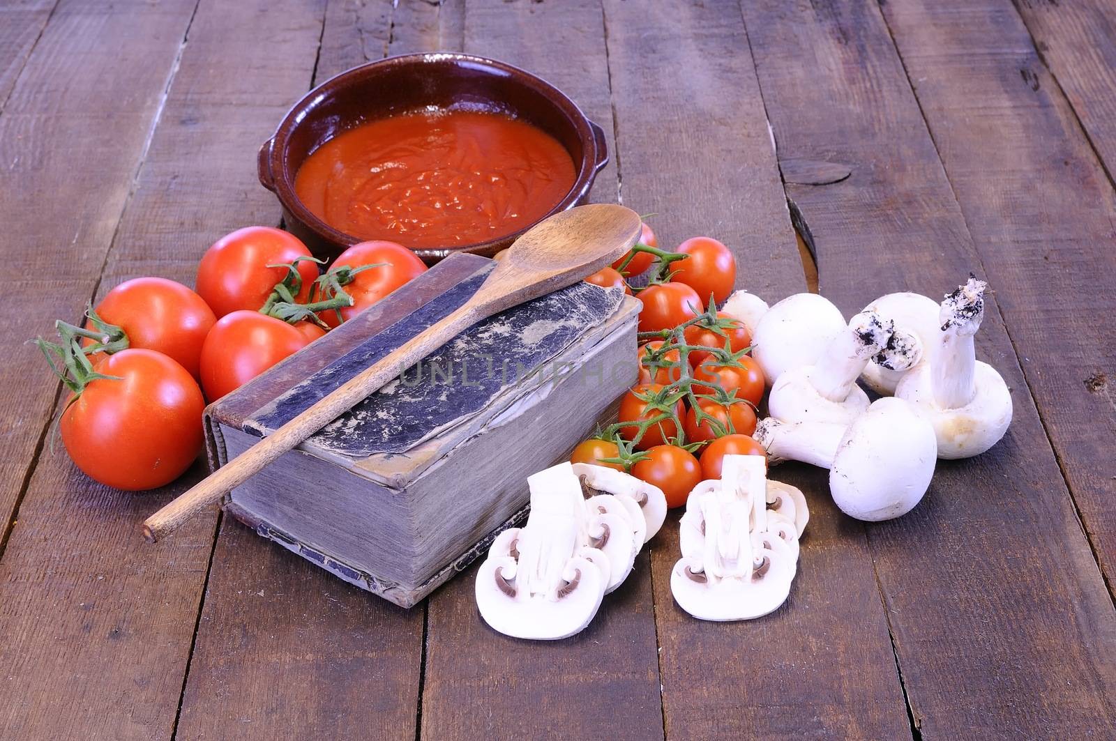 Cookbook over the kitchen table with ingredients.